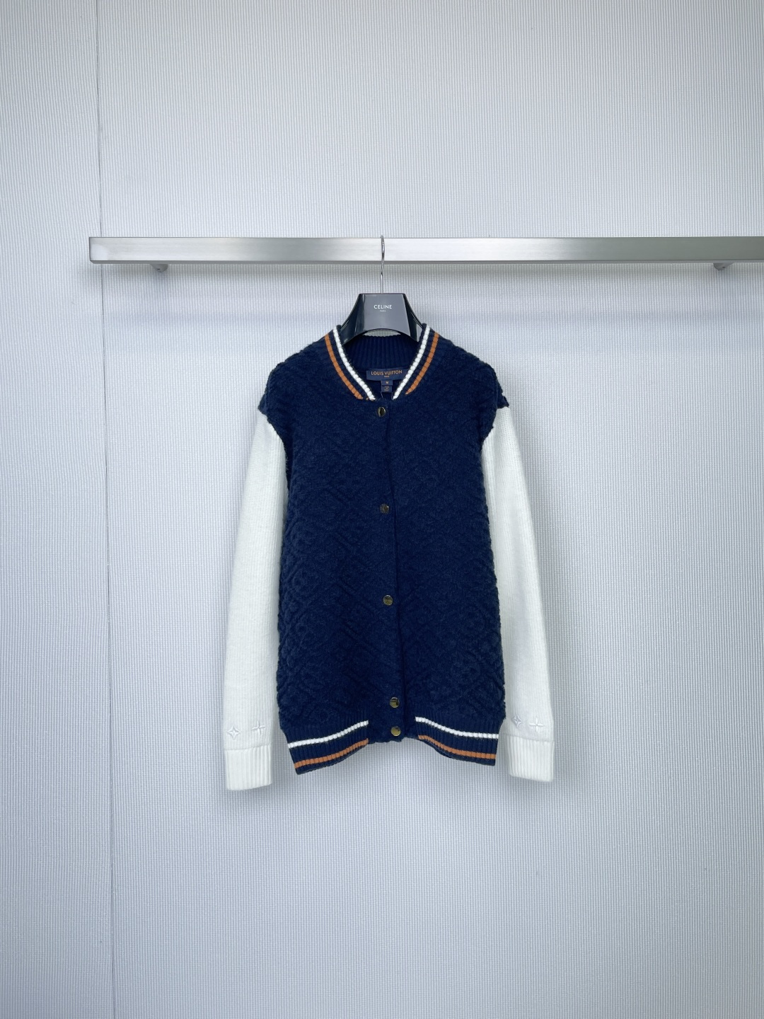 NO:586581,LV women's knitted cardigan, French sporty elegance, classic baseball shirt silhouette reshape, dark blue diamond texture meets pure white ribbed knitted sleeves, colliding with retro college atmosphere, orange and white stripes on the cuffs to enhance the color, dark gold buttons are low-key embellishments, the details show LV's modern genes, the worsted wool fabric is soft and skinny,  The diamond quilting process ensures a crisp silhouette, perfect for all seasons, the ribbed V-neck modifies the neckline, and the short version easily optimizes proportions, with just the right balance between laziness and sophistication. From casual afternoon tea to weekend golf, one piece unlocks a variety of fashionable scenes - a low-key release of French sports chic.  Code numberSML,,louis vuitton,alexander wang19860909LV女士针织开衫,法式运动优雅,经典棒球衫廓形重塑,深蓝菱格纹肌理邂逅纯白罗纹针织袖,碰撞复古学院气息,袖口橙白条纹跃动提色,暗金纽扣低调点缀,细节尽显LV摩登基因,精纺羊毛面料柔软有骨感,菱格绗缝工艺保障廓形挺括,四季皆宜实穿度满分,罗纹V领修饰颈线,短款版型轻松优化比例,慵懒与精致感平衡得恰到好处,从休闲下午茶到周末高尔夫,一件解锁多种时髦场景——低调释放法式运动chic. 码数SML,,louis vuitton,alexander wang,Women's clothing