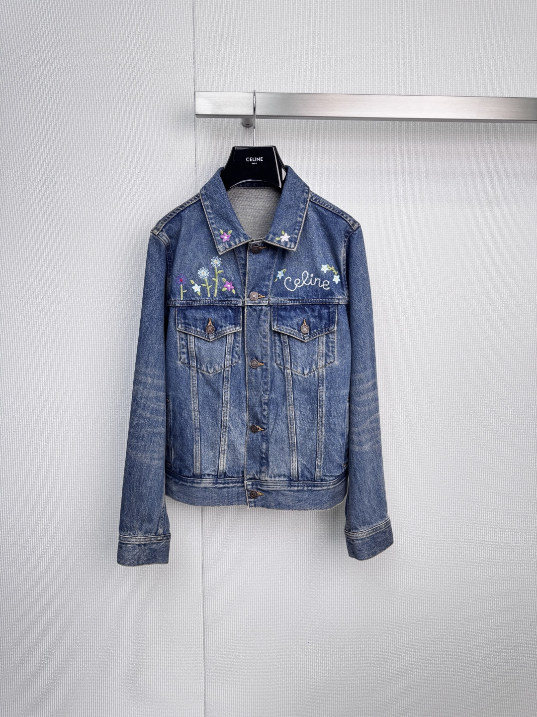 NO:590907,CELINE  The floral statement denim jacket uses denim as the canvas to interpret romantic and uninhibited classic denim and reinvent it. It uses blue denim fabric with rich texture and uses the brand's signature sophisticated tailoring to create a crisp yet comfortable short silhouette. The hand-painted poetry blooms.  Personality, above the collar and pockets, brightly colored clusters of flowers bloom quietly with exquisite embroidery, like a hand-painted oil painting, injecting romance and artistic flavor into the unruly denim, and low-key statement of the white 'CELINE' Paris headquarters font embroidery on the right chest  , echoing the brand logo on the black clothes hanger, highlighting the undoubted brand identity in the details. Wear a simple white T-shirt underneath, black motorcycle shorts or straight trousers, and a pair of ankle boots or retro sneakers. Whether you are interpreting the casual elegance of the streets of Paris or interpreting the personality of an urban woman, you can easily focus on it, wearing it with freedom and sophistication at the same time. Size SML,,celine,boots,sneakers,shorts,jackets  & coats,tees,t-shirt,alexander wang19860909CELINE 花卉宣言牛仔外套,以丹宁为画布,演绎浪漫不羁,经典丹宁,重塑新生,选用质感丰厚的蓝色丹宁面料,以品牌标志性的精良剪裁,打造挺括而不失舒适的短款廓形,手绘诗意,绽放个性,衣领与口袋上方,色彩明媚的簇簇花卉以精致刺绣悄然绽放,犹如一幅手绘油画,为不羁的丹宁注入浪漫与艺术气息,低调宣言右胸前的白色「CELINE」巴黎总部字体刺绣,与黑色衣架上的品牌标识遥相呼应,于细节中彰显毋庸置疑的品牌身份,内搭简约白色T恤,下配黑色机车短裤或直筒长裤,脚踏一双踝靴或复古运动鞋,无论是演绎巴黎街头的随性优雅,还是诠释都市女性的个性型格,皆能轻松定格焦点,将自由与精致同时穿戴在身.码数SML,,celine,boots,sneakers,shorts,jackets & coats,tees，t-shirt,alexander wang,Women's clothing