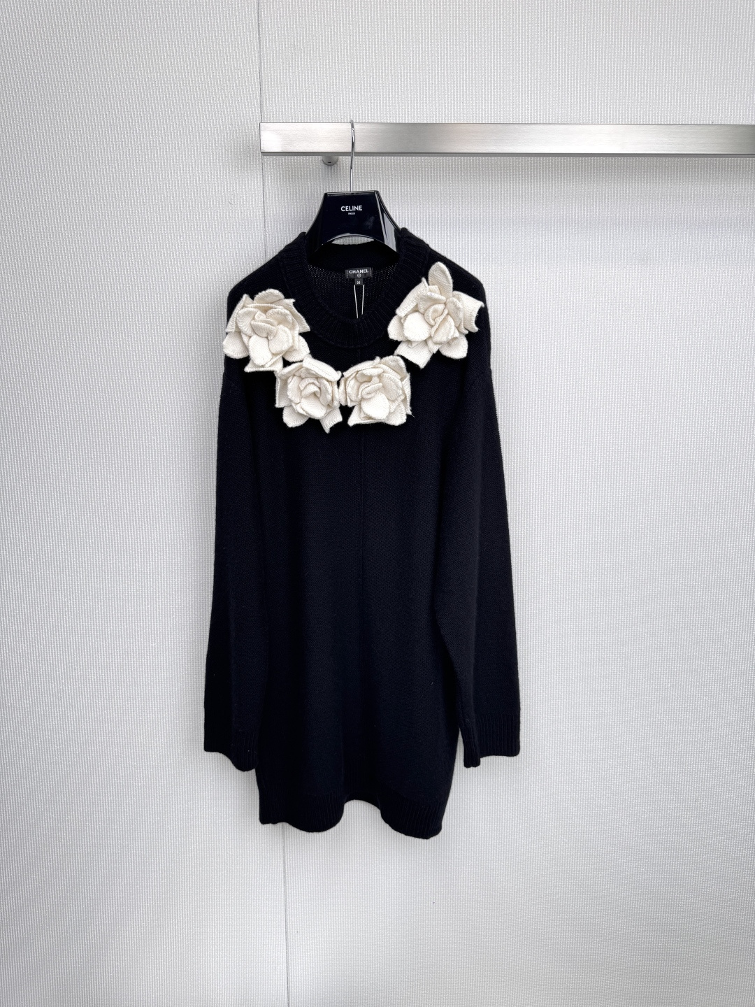 NO:590928,This Chanel black knitted dress interprets timeless elegance with a simple silhouette. Five three-dimensional white camellias bloom quietly at the neckline, injecting a poetic poetry into the deep black. The classic black and white collide, and the brand logo is discreetly embellished on the silver hanger - every detail tells the Chanel style.  The essence of it is extraordinary in low-key, and contains power in femininity. The iconic camellia three-dimensional tailoring integrates advanced customization craftsmanship into daily wear. The delicate stitching outlines the slim curves. It combines French laziness and exquisite tension. From the afternoon salon to the halo of the dinner, it can easily complete the elegant transition between day and night.  Code numberSML,,chanel,chanel,skirts,alexander wang19860909这件Chanel黑色针织连衣裙,以简约轮廓诠释永恒优雅,领口五朵立体白色山茶花悄然绽放,为深邃黑色注入灵动诗意,经典黑白碰撞间,品牌标识低调点缀于银质衣架——每一处细节皆诉说着香奈儿风格的精髓在低调中展现非凡,于柔美中蕴含力量,标志性山茶花立体剪裁,将高级定制工艺融入日常着装,细腻针法勾勒修身曲线,兼具法式慵懒与精致张力,从午后沙龙到晚宴光晕,轻松完成日与夜的优雅过渡. 码数SML,,chanel,chanel,skirts,alexander wang,Women's clothing