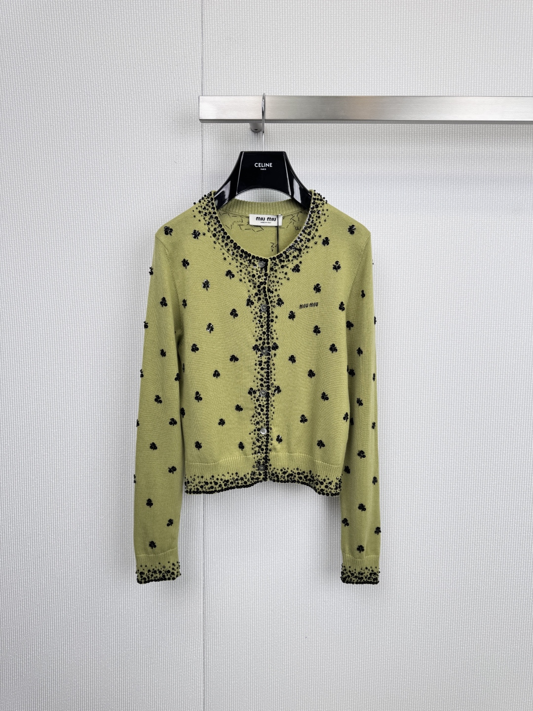 NO:590936,Miu Miu girl's poem sequined knitted cardigan, interpreting Miu  The Miu-style double-sided romantic apricot color is gentle and the olive green is vivid. Between the round neck and the short silhouette, it outlines a just right girly silhouette. The body is decorated with exquisite beaded embroidery - dancing rose gold bows and black four-leaf clover.  Scattered quietly, weaving liveliness and interest into soft needlework, the unique sequin embroidery (the apricot model has a rose gold bow, the green model has a black four-leaf clover pattern) breaks the dullness of the basic knitted style and reflects the delicacy under the light and shadow.  The light shows the brand's iconic playfulness and elegance. The soft apricot color interprets purity and elegance, while the bright olive green brings retro and vitality. The two tones have also become a fashionable tool to lighten up daily looks. The classic round neck design is easy to match; the brand label on the left chest or inside the placket is a low-key proof of extraordinary taste. Whether it is paired with the same series of skirts to create a complete sweet and cool college style, or worn with simple shirts and jeans, it can instantly infuse Miu  Miu's unique 'rebellious girl' soul easily wanders between daytime leisure and evening dating. Size SML,,miumiu,skirts,jeans,shirts,alexander wang19860909Miu Miu少女诗篇珠片针织开衫,诠释Miu Miu式的双面浪漫杏色温柔,橄榄绿鲜活,在圆领与短款廓形间,勾勒出恰到好处的少女感剪影,衣身缀满精致珠片刺绣——玫瑰金色蝴蝶结翩然起舞,黑色四叶草悄然散落,将灵动趣意编织进柔软针线,独具匠心的亮片刺绣（杏色款为玫瑰金色蝴蝶结,绿色款为黑色四叶草图案）,打破基础款针织的沉闷,在光影下折射出细腻光芒,尽显品牌标志性的俏皮与贵气,柔和的杏色色诠释纯净优雅,鲜明的橄榄绿色则带来复古与活力,两种色调,同样成为点亮日常造型的时髦利器,经典的圆领设计,易于搭配；左胸处或衣襟内的品牌标签,低调印证不凡品味,无论是搭配同系列短裙,演绎完整的甜酷学院风,还是内搭简约衬衫、牛仔裤,都能瞬间注入Miu Miu独有的“叛逆少女”灵魂,轻松游走于日间休闲与晚间约会之间.码数SML,,miumiu,skirts,jeans,shirts,alexander wang,Women's clothing