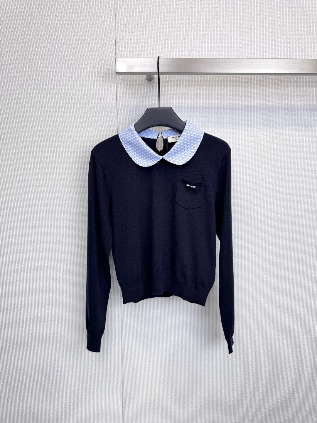 NO:606027,MiuMiu Peter Pan collar two-color sweater, these two sweaters perfectly interpret the brand's iconic aesthetics of sweet retro and preppy style. Every detail is full of exquisite ingenuity. Classic royal blue model, retro playful iconic collar, unique wavy Peter Pan collar, combined with blue pinstripes on the collar and pockets, instantly breaks the calmness of black, injecting a touch of navy style refreshing and girlish playfulness. The small pocket on the left chest and white brand logo.  It has become an unintentional highlight. The overall cut is simple and the material is soft. Whether worn alone or with a shirt, it can easily create a low-key and elegant academic feel. The pure white model is refreshing and healing. The baby doll collar is designed with blue and white pinstripes. The baby collar is refreshing and neat, forming a clean and bright contrast with the pure white background. The button opening design at the neckline adds a cleverness and sophistication. The minimalist aesthetic soft white knitted fabric highlights the gentle temperament. The black 'Miu' on the left chest  Miu' logo has become the visual focus, and the overall style is clean and age-reducing, as if it comes with a lighting board, exuding an effortless sense of fashion and high-end. Size SML,, miumiu, sweaters, shirts, alexander wang19860909MiuMiu彼得潘领双色毛衣,这两件毛衣完美诠释了品牌标志性的甜美复古与学院风融合的美学,每一处细节都透着精致巧思,经典宝蓝色款,复古俏皮标志性领口,独特的波浪形彼得潘领,结合领口与口袋的蓝色细条纹,瞬间打破黑色的沉静,注入一丝海军风的清爽与少女的俏皮感,左胸处的小巧口袋与白色品牌标识,成为不经意的亮点,整体剪裁简约,材质软糯,无论是单穿还是内搭衬衫,都能轻松营造出低调又贵气的学院感,纯净白色款,清爽治愈,娃娃领设计,蓝白细条纹娃娃领清爽利落,与纯白底色形成干净明亮的对比,领口处的纽扣开合设计更添一份乖巧与精致,极简美学柔软的白色针织面料凸显温柔气质,左胸的黑色“Miu Miu”标识成为视觉焦点,整体风格干净减龄,仿佛自带打光板,散发出一种不费力的时髦与高级感.码数SML,,miumiu,sweaters,shirts,alexander wang,Women's clothing