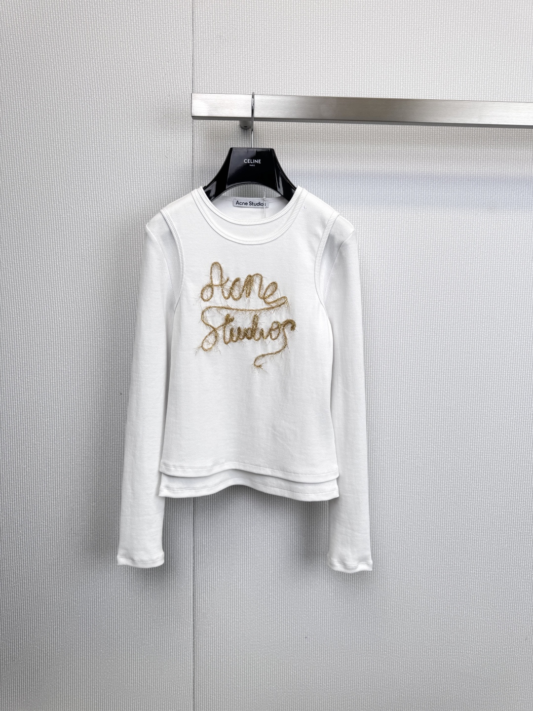 NO:606039,Acne  Studios fake two-piece long-sleeved T-shirt is an indispensable high-end basic model in the wardrobe. It cleverly uses fake two-piece design, eliminating the tediousness of layering, and bringing rich layering and simple fashion attitude in one step. The classic fake two-piece design creates a white inner visual effect at the collar and cuffs, instantly breaking the monotony of solid-color T-shirts. This design not only increases the visual layering, but also avoids the bloat that may be caused by real layering. The golden embroidery 'Acne' on the left chest  Studios' is the finishing touch of the whole. Exquisite embroidery technology highlights the texture and injects a low-key sense of luxury into the pure white background. The use of crisp and skin-friendly cotton fabric ensures the comfort of single wear and the neatness of the silhouette. The overall fit is loose and moderate, which can reflect  Relaxed street style without being too baggy, maintaining the brand's Nordic minimalist origins. The pure white contrasts sharply with the luxurious gold logo. In the simple tone of black, white and gray, it easily becomes the visual focus, highlighting a low-key and confident taste. Size SML,,acne  studios,dior,tees,t-shirt,alexander wang19860909Acne Studios假两件长袖T恤,衣橱里不可或缺的高阶基础款,它巧妙运用假两件设计,省去叠穿的繁琐,一步到位带来丰富的层次感与简约不简单的时尚态度,经典的假两件式设计,在领口、袖口处营造出白色内搭的视觉效果,瞬间打破了纯色T恤的单调,这种设计不仅增加了视觉的层次感,更避免了真实叠穿可能带来的臃肿,左胸前的金色刺绣“Acne Studios”字样是整体的点睛之笔,精致的刺绣工艺凸显质感,为纯净的白色底色注入一丝低调的奢华感,采用挺括且亲肤的棉质面料,确保了单穿的舒适度与廓形的利落感.整体版型宽松适度,既能体现轻松的街头风格,又不会过于松垮,保持了品牌的北欧极简血统,纯净的白色与奢华的金色标识形成鲜明对比,在黑、白、灰的简约基调中,轻松成为视觉焦点,彰显出低调而自信的品味.码数SML,,acne studios,dior,tees，t-shirt,alexander wang,Women's clothing