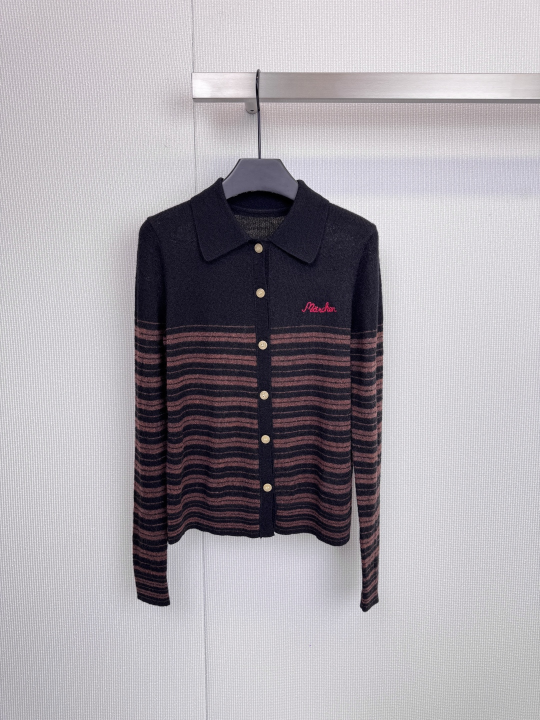 NO:606713,Marchen's classic lapel sweater defines the relaxation and elegance of autumn and winter. It uses simple lines to outline an effortless sense of fashion. This sweater uses soft yarns, a classic lapel and a neat silhouette design. It is a must-have for reshaping your autumn and winter wardrobe.  It is a basic model. The exquisite brand embroidery on the left chest tells the taste in every detail. Whether it is the eye-catching red logo or the elegant white words, it has become the visual focus of the whole outfit. The row of textured gold buttons on the front is not only functional.  It is also a touch of embellishment, cleverly breaking the rhythm of stripes, and injecting a low-key luxury luster into the calm brown and white or gray and white colors. Whether it is the collision of dark brown and the background color, or the gradual transition between gray and white, it exudes a retro and modern atmosphere.  The loose and decent tailoring ensures comfort and can be easily layered to create layers. This is not just a knitted sweater, but also a self-confident armor for you to deal with a variety of occasions. From commuting days to casual weekends, it can bring you warmth and style.  Code number SML,,alexander wang19860909Marchen经典翻领针织衫,定义秋冬的松弛与优雅,以简约线条,勾勒不费力的时髦感,这款针织衫,甄选柔软纱线,采用经典翻领与利落版型设计,重塑秋冬衣橱的必备基础款,左胸处精致的品牌刺绣,于细微处诉说品味,无论是醒目的红色标识,还是优雅的白色字样,都成为整身搭配的视觉焦点,前襟一排质感金色纽扣,不仅是功能所在,更是点缀之笔,巧妙打破条纹的韵律感,为沉稳的棕白或灰白配色注入一抹低调的轻奢光泽,无论是深棕与底色的碰撞,还是灰白间的渐进过渡,都散发着复古而现代的气息,宽松得体的剪裁,确保舒适度的同时,亦能轻松叠穿,营造层次,这不只是一件针织衫,更是你从容应对多种场合的自信铠甲,从通勤日到休闲周末,它都能为你带来温暖与得体. 码数SML,,alexander wang,Women's clothing