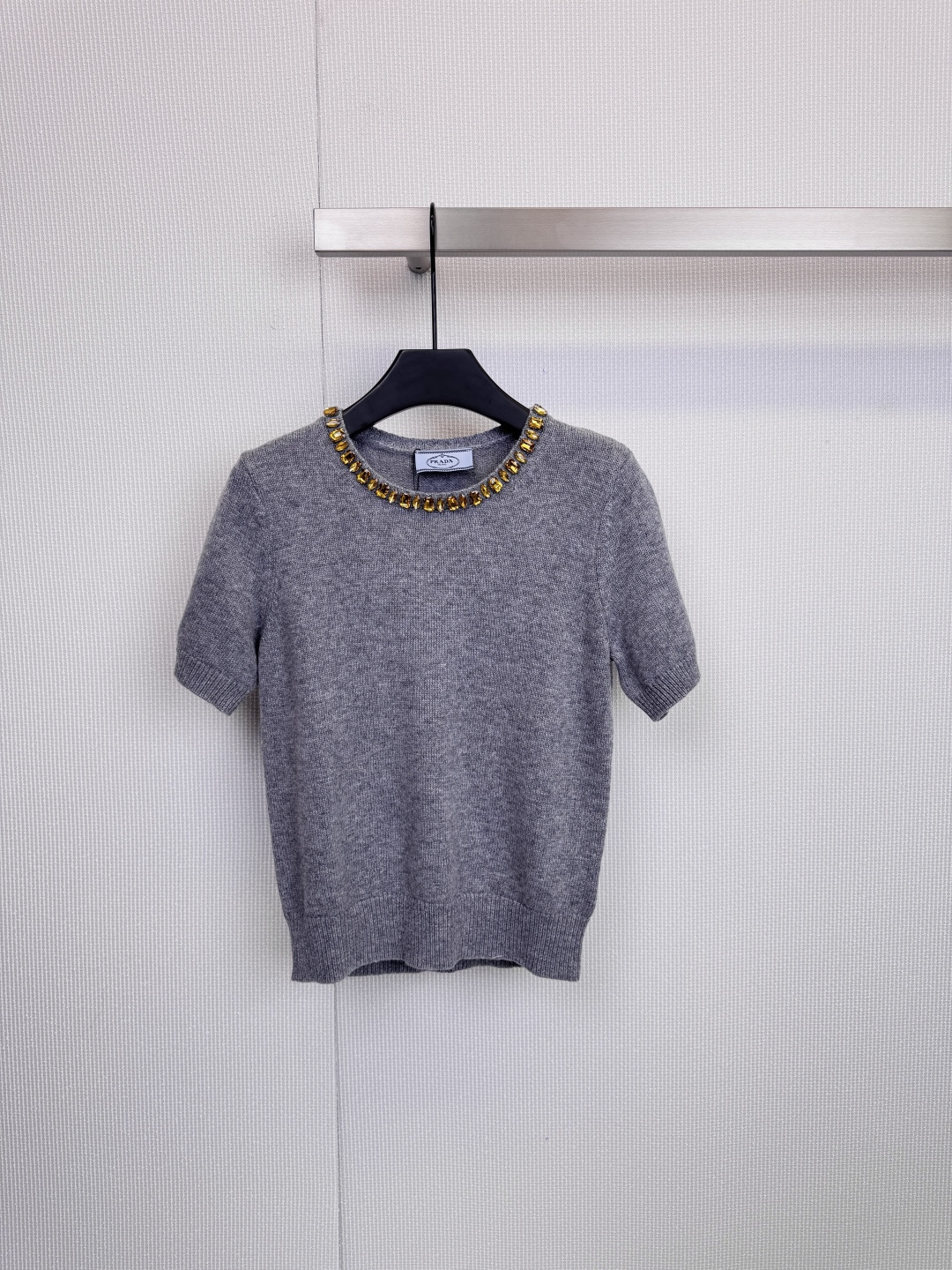 NO:606695,Prada beaded collar knitted short-sleeves are extraordinary in simplicity. With its exquisite craftsmanship and modern design, this knitted short-sleeved shirt has become a wardrobe choice for tasteful people. The item is made of high-quality wool knitted fabric, which has a delicate and flexible touch. The silhouette is neat and crisp. The finishing touch is the neckline. Ingenious custom beads surround the collar, like a tall  A gorgeous, custom-made necklace, the dark blue model is paired with brilliant silver beads and diamonds, showing light in a calm manner, the caramel color model is decorated with retro green beads, demonstrating low-key luxury, and the light gray model is paired with warm golden yellow, showing a gentle and high-end feel. It is well-fitting and tailored, and can be worn without worry. Every detail reflects Prada's ultimate pursuit of aesthetics and wearing experience.  Size SML,,prada,T-shirt,necklace,alexander wang19860909Prada珠饰领口针织短袖,于简约中见非凡,这款针织短袖以其精湛工艺与摩登设计,成为品味人士的衣橱挚选,单品采用高品质羊毛针织面料,触感细腻柔韧,廓形利落挺括,点睛之笔在于领口,匠心独运的定制珠饰环绕领边,宛如高级定制的华丽项链,深蓝色款搭配璀璨银色珠钻,冷静中透出光芒,焦糖色款缀以复古绿珠,演绎低调的奢华,浅灰色款则配以温暖金黄色,尽显温柔高级感,合身剪裁,穿着无忧,细节之处,皆是Prada对美学与穿着体验的至臻追求. 码数SML,,prada,T-shirt,necklace,alexander wang,Women's clothing