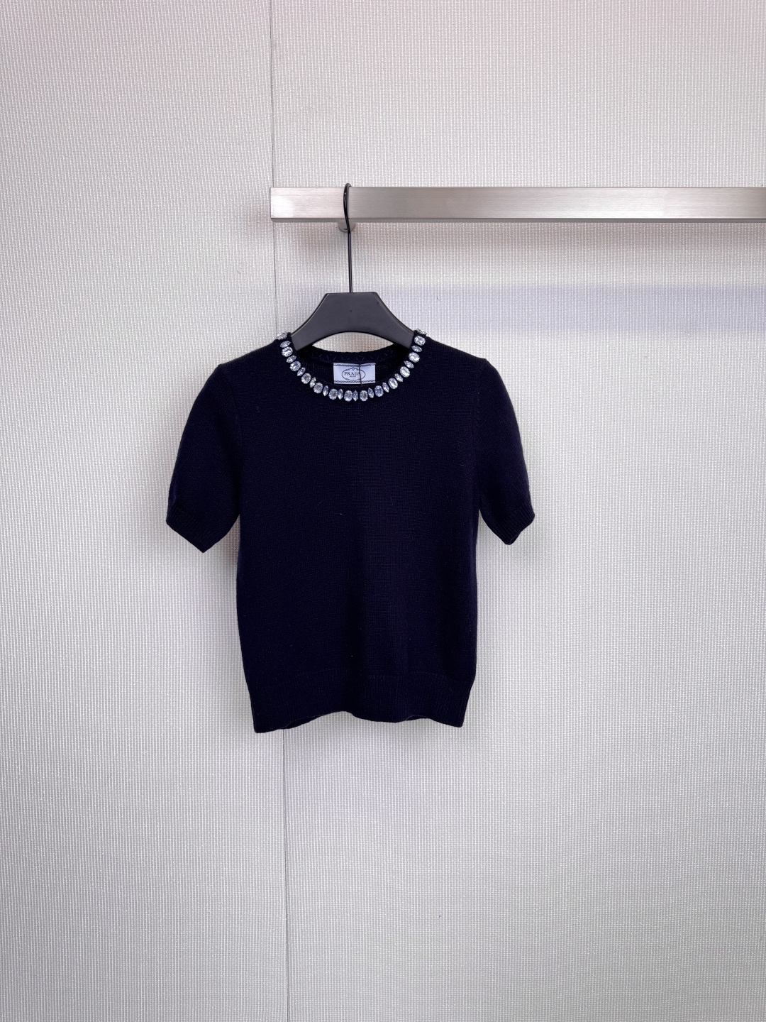 NO:606725,Prada beaded collar knitted short-sleeves are extraordinary in simplicity. With its exquisite craftsmanship and modern design, this knitted short-sleeved shirt has become a wardrobe choice for tasteful people. The item is made of high-quality wool knitted fabric, which has a delicate and flexible touch. The silhouette is neat and crisp. The finishing touch is the neckline. Ingenious custom beads surround the collar, like a tall  A gorgeous, custom-made necklace, the dark blue model is paired with brilliant silver beads and diamonds, showing light in a calm manner, the caramel color model is decorated with retro green beads, demonstrating low-key luxury, and the light gray model is paired with warm golden yellow, showing a gentle and high-end feel. It is well-fitting and tailored, and can be worn without worry. Every detail reflects Prada's ultimate pursuit of aesthetics and wearing experience.  Size SML,,prada,T-shirt,necklace,alexander wang19860909Prada珠饰领口针织短袖,于简约中见非凡,这款针织短袖以其精湛工艺与摩登设计,成为品味人士的衣橱挚选,单品采用高品质羊毛针织面料,触感细腻柔韧,廓形利落挺括,点睛之笔在于领口,匠心独运的定制珠饰环绕领边,宛如高级定制的华丽项链,深蓝色款搭配璀璨银色珠钻,冷静中透出光芒,焦糖色款缀以复古绿珠,演绎低调的奢华,浅灰色款则配以温暖金黄色,尽显温柔高级感,合身剪裁,穿着无忧,细节之处,皆是Prada对美学与穿着体验的至臻追求. 码数SML,,prada,T-shirt,necklace,alexander wang,Women's clothing