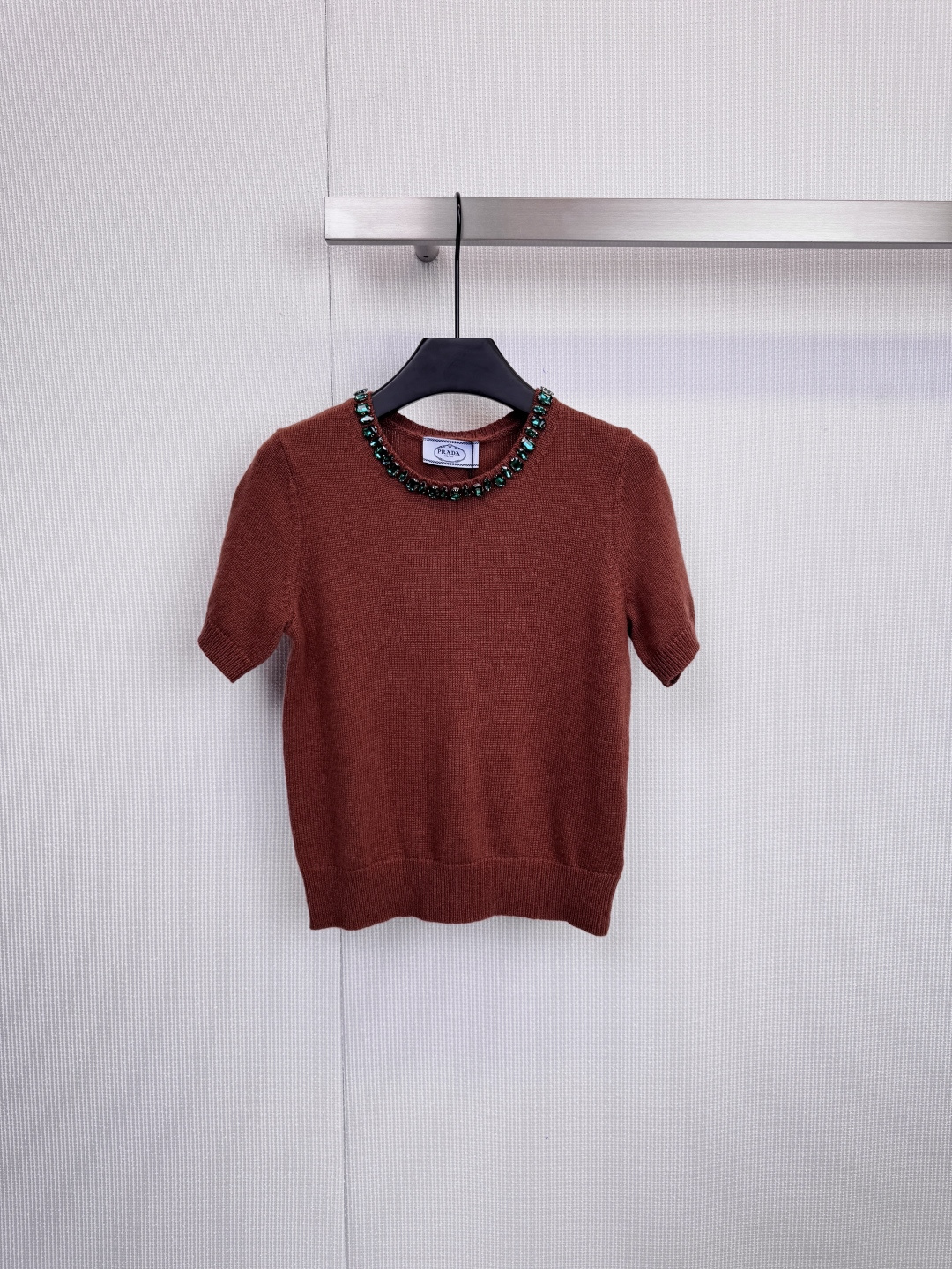 NO:606735,Prada beaded collar knitted short-sleeves are extraordinary in simplicity. With its exquisite craftsmanship and modern design, this knitted short-sleeved shirt has become a wardrobe choice for tasteful people. The item is made of high-quality wool knitted fabric, which has a delicate and flexible touch. The silhouette is neat and crisp. The finishing touch is the neckline. Ingenious custom beads surround the collar, like a tall  A gorgeous, custom-made necklace, the dark blue model is paired with brilliant silver beads and diamonds, showing light in a calm manner, the caramel color model is decorated with retro green beads, demonstrating low-key luxury, and the light gray model is paired with warm golden yellow, showing a gentle and high-end feel. It is well-fitting and tailored, and can be worn without worry. Every detail reflects Prada's ultimate pursuit of aesthetics and wearing experience.  Size SML,,prada,T-shirt,necklace,alexander wang19860909Prada珠饰领口针织短袖,于简约中见非凡,这款针织短袖以其精湛工艺与摩登设计,成为品味人士的衣橱挚选,单品采用高品质羊毛针织面料,触感细腻柔韧,廓形利落挺括,点睛之笔在于领口,匠心独运的定制珠饰环绕领边,宛如高级定制的华丽项链,深蓝色款搭配璀璨银色珠钻,冷静中透出光芒,焦糖色款缀以复古绿珠,演绎低调的奢华,浅灰色款则配以温暖金黄色,尽显温柔高级感,合身剪裁,穿着无忧,细节之处,皆是Prada对美学与穿着体验的至臻追求. 码数SML,,prada,T-shirt,necklace,alexander wang,Women's clothing