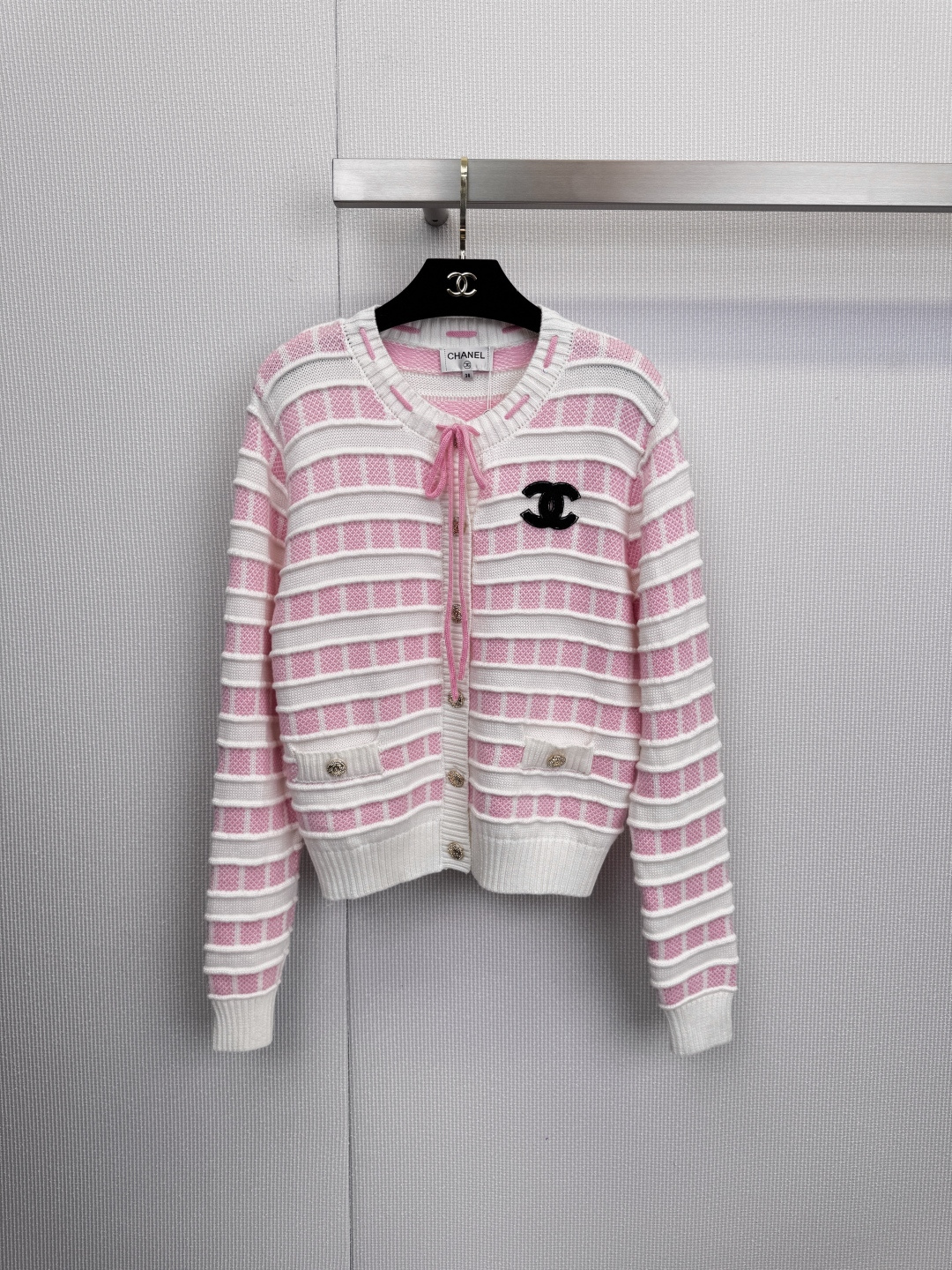 NO:607792,Encounter soft and sweet dreams, Chanel pink and white striped cardigan, engraved romance into the genes, the spring breeze blows through the corners of the clothes, awakening the soft and sweet dreams of the wardrobe. This pink and white striped cardigan is undoubtedly the perfect answer to spring romance. The delicate pink and pure white are intertwined, like clouds kissed by the sunset.  Just the right color saturation, regardless of skin color, it can be worn easily with a gentle and high-end feel, instantly lighting up the spring mood. The bow tie of the same color on the neckline is the finishing touch of the overall look. It can be tied into a bow at will, adding playfulness and elegance, or it can hang down naturally, casual and lazy. The classic black double C on the chest  The golden buttons on the logo and pockets silently interpret Chanel's timeless style in details. It is made of top-grade blended fabric of 70% wool and 30% cashmere. It feels as light and soft as a cloud. It not only brings impeccable warmth, but also ensures the ultimate comfort experience of wearing next to the skin, giving you the sense of security of being gently wrapped. A perfect cardigan is enough to define the romantic tone of the entire season. Size SML,,chanel,chanel,alexander wang19860909邂逅软糯甜梦,Chanel小香粉白条纹开衫,将浪漫刻入基因,春风拂过衣角,唤醒了衣橱的软糯甜梦,这件粉白相间的条纹开衫,无疑是春日浪漫的满分答案,细腻的粉与纯净的白交织,如同被晚霞亲吻过的云朵.恰到好处的色彩饱和度,不挑肤色,轻松穿出温柔高级感,瞬间点亮春日心情,领口的同色系蝴蝶结系带,是整体造型的点睛之笔,可随意系成蝴蝶结,增添俏皮与优雅,亦可自然垂落,随性又慵懒,胸前经典的黑色双C Logo与口袋上的金色纽扣,于细节处无声诠释着香奈儿的永恒风格,采用70羊毛与30羊绒的顶级混纺面料,触感如云朵般轻盈软糯,不仅带来了无可挑剔的保暖度,更确保了贴肤穿着的极致舒适体验,给予你被温柔包裹的安全感,一件完美的开衫,足以定义一整个季节的浪漫基调.码数SML,,chanel,chanel,alexander wang,Women's clothing