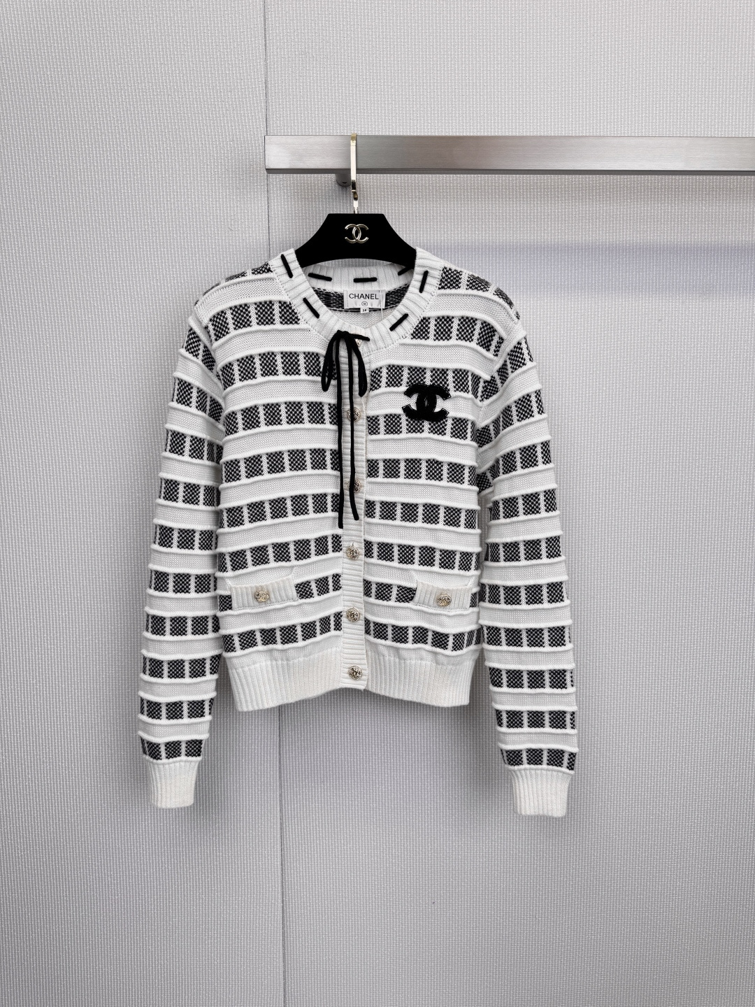 NO:607802,Encounter soft and sweet dreams, Chanel pink and white striped cardigan, engraved romance into the genes, the spring breeze blows through the corners of the clothes, awakening the soft and sweet dreams of the wardrobe. This pink and white striped cardigan is undoubtedly the perfect answer to spring romance. The delicate pink and pure white are intertwined, like clouds kissed by the sunset.  Just the right color saturation, regardless of skin color, it can be worn easily with a gentle and high-end feel, instantly lighting up the spring mood. The bow tie of the same color on the neckline is the finishing touch of the overall look. It can be tied into a bow at will, adding playfulness and elegance, or it can hang down naturally, casual and lazy. The classic black double C on the chest  The golden buttons on the logo and pockets silently interpret Chanel's timeless style in details. It is made of top-grade blended fabric of 70% wool and 30% cashmere. It feels as light and soft as a cloud. It not only brings impeccable warmth, but also ensures the ultimate comfort experience of wearing next to the skin, giving you the sense of security of being gently wrapped. A perfect cardigan is enough to define the romantic tone of the entire season. Size SML,,chanel,chanel,alexander wang19860909邂逅软糯甜梦,Chanel小香粉白条纹开衫,将浪漫刻入基因,春风拂过衣角,唤醒了衣橱的软糯甜梦,这件粉白相间的条纹开衫,无疑是春日浪漫的满分答案,细腻的粉与纯净的白交织,如同被晚霞亲吻过的云朵.恰到好处的色彩饱和度,不挑肤色,轻松穿出温柔高级感,瞬间点亮春日心情,领口的同色系蝴蝶结系带,是整体造型的点睛之笔,可随意系成蝴蝶结,增添俏皮与优雅,亦可自然垂落,随性又慵懒,胸前经典的黑色双C Logo与口袋上的金色纽扣,于细节处无声诠释着香奈儿的永恒风格,采用70羊毛与30羊绒的顶级混纺面料,触感如云朵般轻盈软糯,不仅带来了无可挑剔的保暖度,更确保了贴肤穿着的极致舒适体验,给予你被温柔包裹的安全感,一件完美的开衫,足以定义整个季节的浪漫基调.码数SML,,chanel,chanel,alexander wang,Women's clothing