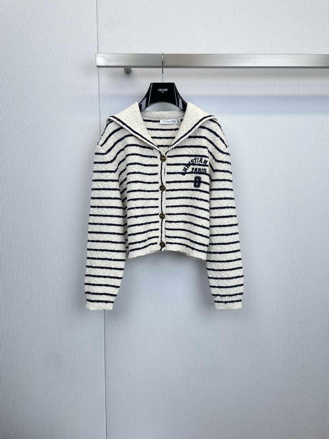 NO:608730,Dior navy knitted cardigan is a classic and elegant nautical poem. This navy knitted cardigan perfectly combines French elegance with the unrestrained freedom of nautical style. It is an indispensable classic in the wardrobe. It is not only a cardigan, but also a statement piece.  A piece that shows taste and fashion attitude, with iconic nautical elements, using timeless classic black and white/off-white and navy stripes, which instantly evokes the yearning for the Côte d'Azur and holiday style. The loose and moderate version combines comfort and fashion. The eye-catching left chest  “CHRISTIAN DIOR PARIS”  The embroidered logo, supplemented by the unique number '8', shows the brand's heritage in a low-key manner, and is the finishing touch of the overall design. The classic navy-style large lapel design is neat and stylish. A whole row of brown buttons is embellished, adding a touch of refreshing navy color.  The retro and warm texture enriches the overall visual hierarchy. The short design, which is slightly higher than the waistline, can optimize body proportions and can be easily matched with high-waisted pants or skirts. It visually lengthens the leg lines and makes it look particularly sharp. It can be used directly as a top.  Pair it with shorts or a pleated skirt, a straw hat and canvas shoes, and you will instantly transform into a fashionable girl on a seaside vacation. With its impeccable details, top-quality fabrics and classic design, this cardigan has become the perfect bridge between leisure and elegance. Whether it is daily outing or vacation travel, it allows you to easily control a variety of styles and show your unique fashion taste. Size SML, dior, skirts, shorts, hats, alexander  wang19860909Dior海军风针织开衫,经典与优雅的航海诗篇,这款海军风针织开衫,将法式优雅与航海风格的洒脱不羁完美融合,是衣橱中不可或缺的经典之作,它不仅仅是一件开衫,更是一件彰显品味与时尚态度的单品,标志性航海元素,采用永恒经典的黑白/米白与藏蓝相间条纹,瞬间唤起对蔚蓝海岸与假日风情的向往,宽松适度的版型,兼具舒适度与时髦感,左胸前醒目的 “CHRISTIAN DIOR PARIS” 刺绣标识,辅以独特的数字“8”,低调中尽显品牌底蕴,是整体设计的点睛之笔,经典的海军风大翻领设计,利落有型.一整排棕色纽扣的点缀,为清爽的海军色调增添了一抹复古温暖的质感,丰富了整体的视觉层次,略高于腰线的短款设计,能够优化身材比例,轻松搭配高腰裤或半身裙,在视觉上拉长腿部线条,显得格外精神利落,直接作为上衣,搭配短裤或百褶半裙,再配上一顶草帽与帆布鞋,即刻化身海滨度假的时髦女郎,这件开衫以其无可挑剔的细节、顶级的面料和经典的设计,成为连接休闲与优雅的完美桥梁,无论是日常出街还是度假旅行,它都能让您从容驾驭多种风格,展现出独到的时尚品味.码数SML,,dior,skirts,shorts,hats,alexander wang,Women's clothing