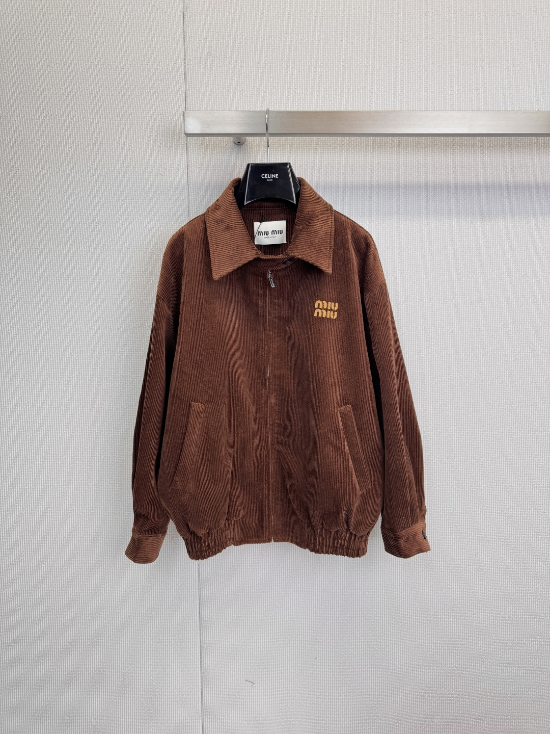 NO:611107,MiuMiu's 2025 new corduroy lapel jacket uses classic brown corduroy fabric to reshape the fashionable silhouette. The unique texture and texture, with its own warm retro filter, show high-end style in a low-key manner. The lapel design and front zipper are neat and stylish, and easily outline the neck line. The exquisite yellow 'Miu' on the left chest  Miu' embroidered logo becomes the finishing touch to highlight the brand identity. The practical pockets on both sides and the elasticated cuffs on the hem and cuffs are designed to be both functional and stylish, creating a lazy yet structured silhouette. Whether worn with a simple T-shirt and jeans to create a casual street style, or paired with a dress to create a balance of femininity and handsomeness, this jacket is an indispensable fashion tool in your wardrobe.,,miumiu,skirts,jeans,jackets &  coats,jackets & coats,tees,t-shirt,alexander wang19860909MiuMiu2025新款灯芯绒翻领夹克外套,以经典棕色灯芯绒面料重塑时尚轮廓.独特的纹理质感,自带温暖复古滤镜,于低调中尽显高级格调,翻领设计与正面拉链,利落有型,轻松勾勒颈部线条,左胸处精致的黄色「Miu Miu」刺绣标识,成为点睛之笔,彰显品牌身份,两侧实用口袋与下摆、袖口的松紧收口设计,兼具功能性与造型感,营造慵懒又不失结构的廓形,无论是内搭简约T恤与牛仔裤,演绎随性街头风,还是搭配连衣裙,混搭出柔美与帅气的平衡感,这件夹克都是你衣橱里不可或缺的时尚利器.,,miumiu,skirts,jeans,jackets & coats,jackets & coats,tees，t-shirt,alexander wang,Women's clothing