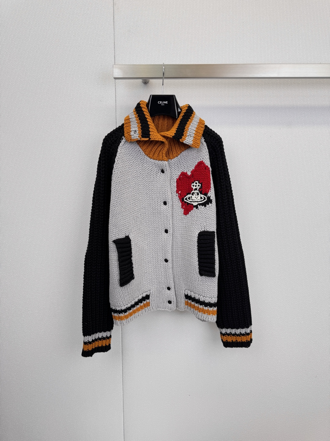 NO:611097,The Queen Mother Red Label series thick-knit sweater cardigan interprets uninhibited British romance with classic contrasting colors. This Queen Mother sweater cardigan injects the brand's rebellious genes into an elegant silhouette, making every appearance a statement of style. The red love Saturn badge on the left chest is the soul of the entire cardigan. The embroidery is exquisite, and the Saturn ring pattern and dripping effect highlight Vivienne Westwood  Iconic joking and rebellion, the sharp contrast between the light gray main color and black sleeves is clean and neat. The yellow and black stripes are cleverly embellished on the collar, cuffs and hem, instantly brightening the overall look and injecting vitality and academic atmosphere. The classic cardigan style, with black buttons and practical patch pockets, takes into account simple style and daily functionality, whether worn with a simple white T-shirt or jeans.  Pants, to interpret the casual street feel, or paired with a shirt dress, adding a sense of coolness and layering to the softness. This cardigan is an indispensable 'styling tool' in your wardrobe. Size SML, skirts, jeans, sweaters, shirts, tees, t-shirt, alexander  wang19860909西太后红标系列粗针毛衣开衫,以经典撞色演绎不羁的英伦浪漫,这件西太后毛衣开衫,将品牌的叛逆基因注入优雅廓形,让每一次亮相都成为风格的宣言,左胸前的红色爱心土星徽章是整件开衫的灵魂.刺绣工艺精细,土星环图案与滴落效果彰显出 Vivienne Westwood 标志性的戏谑与反叛,浅灰主色调与黑色袖子的鲜明对比,干净利落,黄黑条纹在领口、袖口及下摆巧妙点缀,瞬间提亮整体造型,注入活力与学院气息,经典的开衫版型,搭配黑色纽扣与实用贴袋,兼顾简约风范与日常功能性,无论是内搭简约白T恤与牛仔裤,诠释随性街头感,还是搭配衬衫连衣裙,于柔美中增添一份帅气与层次,这件开衫都是你衣橱里不可或缺的“造型利器”.码数SML,,skirts,jeans,sweaters,shirts,tees，t-shirt,alexander wang,Women's clothing