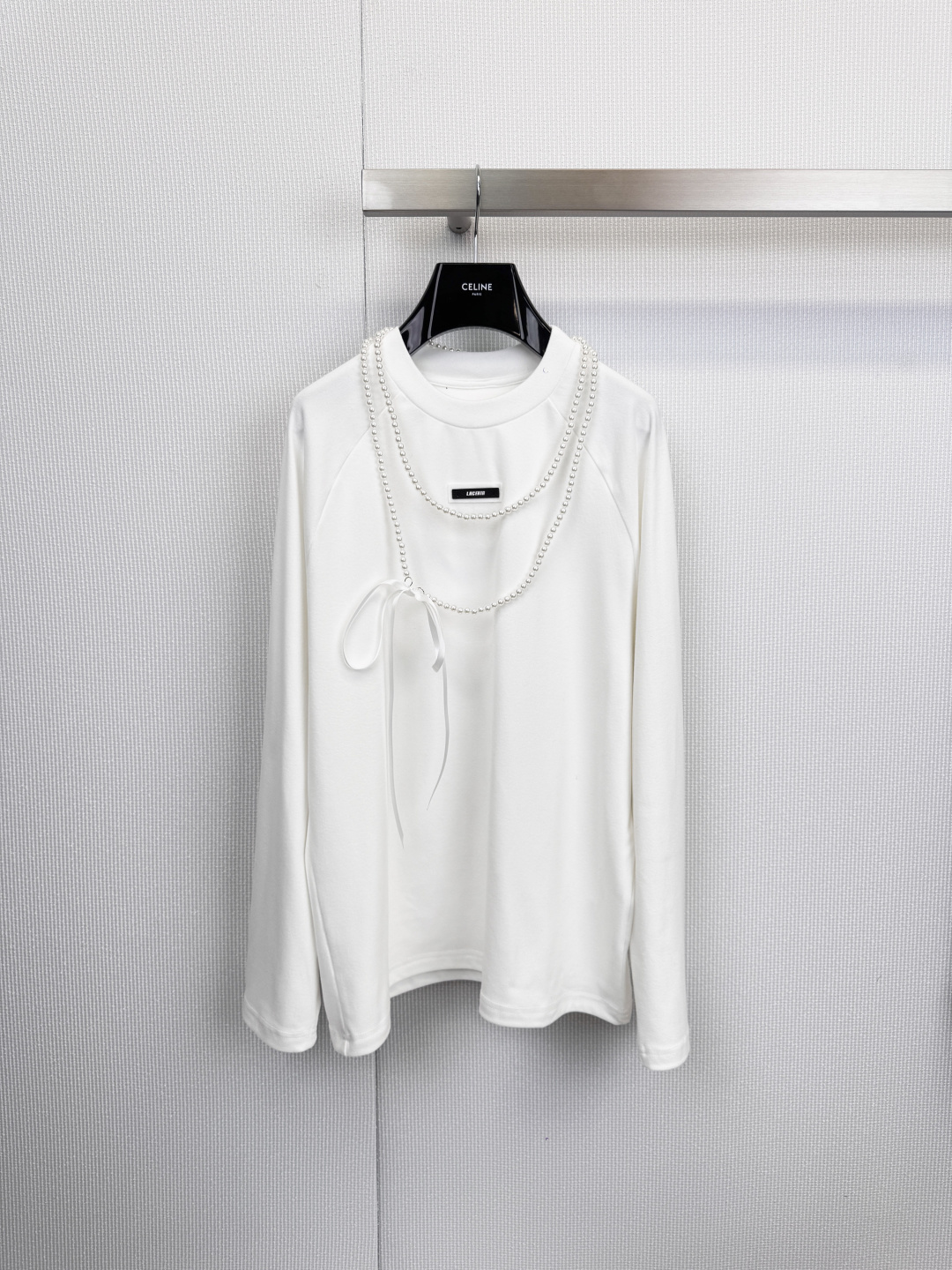 NO:611076,LACERTA  25AW German velvet detachable pearl necklace long-sleeved T-shirt, a sweet and cool layering tool, unlocks multiple retro charms, bid farewell to the monotony of basic T-shirts, this season launches the full-design German velvet long-sleeved T-shirt, redefined with exquisite pearl necklaces and romantic bows  The fashionable rules for autumn and winter inner wear can easily create a multi-faceted style that can be salty or sweet. The double-layered imitation pearl necklace has a retro and elegant double-layered pearl necklace on the body. It has a strong three-dimensional effect and instantly enhances the sophistication and nobility of the overall look. The detachable white bow,  The white bow ribbon embellished on the chest injects a romantic girl's heart. The biggest highlight is the detachable design. You can freely switch between 'sweet lady' and 'simple cool' in one second, realizing one garment for multiple wears. It is made of the popular German velvet material, and the fabric is soft and comfortable.  It has a subtle warm velvet texture, which brings better warmth and temperature locking effect than ordinary cotton. It is a comfortable choice for layering or wearing alone in autumn and winter. Size SML, tees, t-shirt, necklace, alexander  wang19860909LACERTA 25AW德绒可拆卸珍珠项链长袖T恤,甜酷叠穿神器,解锁多重复古魅力,告别基础款T恤的单调,本季重磅推出设计感十足的德绒长袖T恤,以精致的珍珠项链与浪漫蝴蝶结,重新定义秋冬内搭的时髦法则,轻松塑造“可盐可甜”的多面风格,双层仿珍珠项链,衣身自带复古雅致的双层珍珠项链,立体感强,瞬间提升整体造型的精致度与贵气感,可拆卸白色蝴蝶结,胸前点缀的白色蝴蝶结丝带,注入浪漫少女心,最大亮点在于可拆卸设计,一秒即可在“甜美名媛”与“简约酷感”之间自由切换,实现一衣多穿,采用备受青睐的德绒材质,面料软糯亲肤,并带有细微暖绒质感,带来优于普通棉质的保暖锁温效果,是秋冬季节叠穿或单穿的舒适之选.码数SML,,tees，t-shirt,necklace,alexander wang,Women's clothing