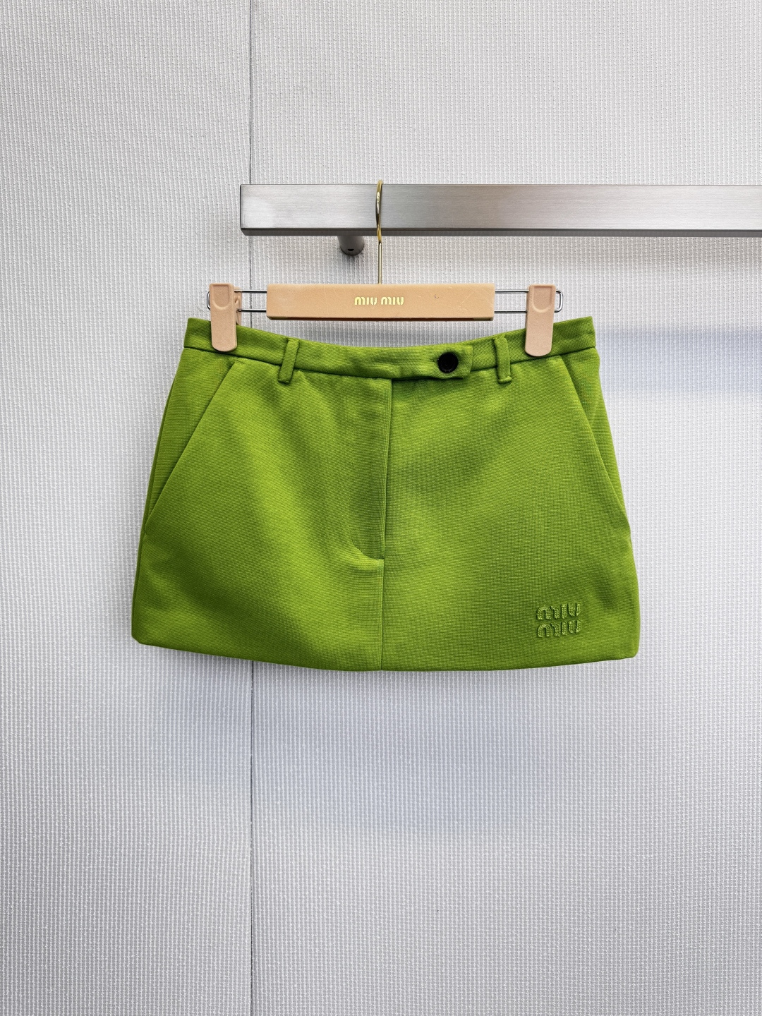 NO:621542,MiuMiu's 2026 spring green skirt opens the prelude to spring with a touch of bright grass green. This skirt has a high-waisted A-line silhouette to outline neat lines. The crisp tailoring gives the body elegant tension. The saturated green tone pops out before the eyes, as full of life as the sprouts of early spring, easily becoming the focus of the eye. The front is embellished with black buttons and straps, colliding with the sense of retro and modern interweaving. The symmetrical diagonal pockets take into account both practicality and style, and the delicate embroidery texture  The brand's sophisticated genes are hidden. Whether it is paired with a simple knitted sweater to create an urban modern look, or combined with a shirt to create a smart aura, it can instantly enhance the texture level of the overall look. With the iconic design language, it cleverly combines the classic silhouette with contemporary interest - it is not only a skirt, but also a green statement full of attitude in the wardrobe. Size SML, miumiu, skirts, shirts, alexander  wang19860909MiuMiu2026春款绿色半裙,以一抹鲜亮草绿,开启春日序曲,这条半裙以高腰A字廓形勾勒利落线条,挺括剪裁赋予身形优雅张力,饱和的绿色调跃然眼前,如初春新芽般充满生机,轻松成为视觉焦点,正面黑色纽扣与袢带点缀,碰撞出复古与摩登的交织感,对称斜插口袋兼顾实用与造型,而细腻的刺绣纹理则暗藏品牌精工基因,无论是搭配简约针织衫演绎都市摩登,或与衬衫组合打造干练气场,皆能瞬间提升整体造型的质感层次,以标志性设计语言,将经典廓形与当代趣味巧妙融合——不止是一件半裙,更是衣橱里充满态度的绿色宣言.码数SML,,miumiu,skirts,shirts,alexander wang,Women's clothing