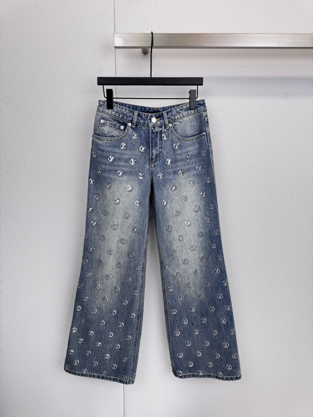 NO:621541,The LV logo is printed all over with silver light, injecting an undeniable luxury aura into the light blue washed jeans. With its loose straight fit, distressed treatment and rivet decoration on the back pocket, this pair of jeans accurately strikes the balance between high-end fashion and street style. The logo is printed all over, showing fearless confidence. From the trousers to the back pocket, the Monogram pattern is densely presented in silver, forming a strong visual impact of the brand. It is the most distinctive brand on the street.  The status medal, with sculpted details, interprets the uninhibited style. The rivet-reinforced design of the back pocket and the raw edge of the trousers reveal ruggedness and spontaneity in the details, showing a carefully crafted 'unfinished' feeling. It is full of style, loose silhouette, and carries multiple styles. Whether it is paired with a simple T-shirt or luxurious fur, it can become the cornerstone of the style, easily walking between casual and grand, showing strong style plasticity. Size SML, Louis  vuitton,jeans,tees,t-shirt,alexander wang19860909LV标志以满印银芒,为浅蓝水洗牛仔注入不容置疑的奢华气场,这条牛仔裤以其宽松直筒的版型、做旧处理与后袋的铆钉装饰,精准拿捏了高端时装与街头不羁的平衡点,满印Logo,彰显无畏自信,从裤身到后袋,Monogram图案以银色姿态密集呈现,构成强大的品牌视觉冲击力,是街头中最鲜明的身份勋章,细节雕琢,诠释不羁型格,后袋铆钉加固设计与毛边裤脚,于细节处流露粗犷与随性,展现经过精心雕琢的“未完成”感,风格十足,宽松廓形,承载多元风格,无论是搭配简约T恤或是奢华皮草,它都能成为造型的基石,轻松游走于休闲与隆重之间,展现强大的风格可塑性.码数SML,,louis vuitton,jeans,tees，t-shirt,alexander wang,Women's clothing