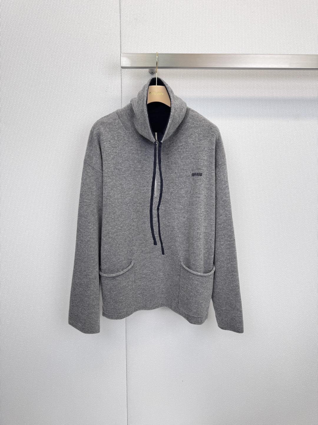 NO:621549,MiuMiu half-zip cashmere sweater, relaxed aesthetics, gentle definition, when delicate cashmere meets sports inspiration, this MIU was born  MIU half-zip cashmere sweater, based on light gray tones, cleverly balances laziness and exquisite texture, becoming an indispensable gentle armor in the autumn and winter wardrobe. It is made of high-quality cashmere material and wraps the body and mind with a soft and skin-friendly touch. It is light but warm, making this sweater  This single item can withstand the slight cold in autumn and winter without looking bulky, showing a low-key luxury texture. The unique half-high collar zipper design allows you to adjust the collar height as you like. It can be worn multiple times. It is paired with a naturally hanging black drawstring, injecting a hint of casual sports vitality into simplicity.  , easily switch between casual and sophisticated styles, loose yet stylish design, curved pockets on both sides naturally blend into the body lines, and the brand logo on the left chest is low-key embellishment, highlighting the brand identity in the details, interpreting the effortless sense of luxury. Whether it is paired with a skirt of the same color to show a gentle and intellectual, or combined with jeans to create a casual look, this cashmere sweater can become the finishing touch of the overall outfit with its simple but not simple design. Size SML, miumiu, skirts, jeans, alexander  wang19860909MiuMiu半拉链羊绒衫,松弛美学,温柔定义,当细腻羊绒遇见运动灵感,便诞生了这件MIU MIU半拉链羊绒衫,它以浅灰色调为基调,将慵懒松弛与精致质感巧妙平衡,成为秋冬衣橱中不可或缺的温柔铠甲,精选高品质羊绒材质,以柔软亲肤的触感包裹身心,轻盈却保暖的特性,让这件单品在秋冬季节既能抵御微寒,又不显臃肿,尽显低调的奢华质感,独特的半高领拉链设计,可随心意调节领口高度,一衣多穿,搭配自然垂落的黑色抽绳,在简约中注入一丝不经意的运动活力,轻松切换休闲与精致风格,宽松而不失型的版型设计,两侧弧形口袋自然融入衣身线条,左胸处的品牌标志低调点缀,于细节中彰显品牌身份,诠释不费力的高级感,无论是搭配同色系半裙演绎温柔知性,还是与牛仔裤组合打造休闲造型,这件羊绒衫都能以其简约而不简单的设计,成为整体穿搭的点睛之笔.码数SML,,miumiu,skirts,jeans,alexander wang,Women's clothing