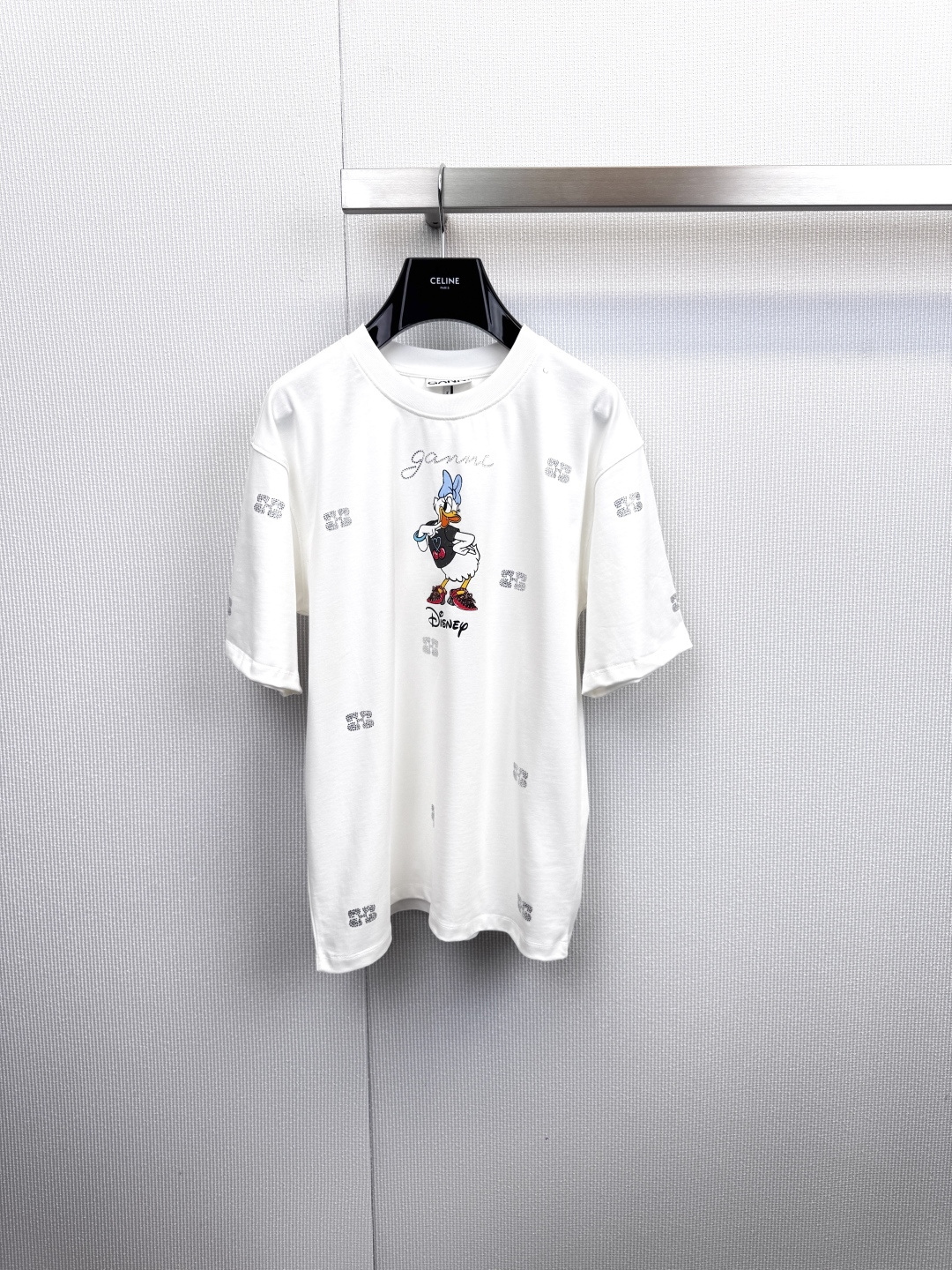 NO:623089,Sparkling Diamond Daisy will guarantee all your turning heads in the summer of 2026. GANNI x Disney is so good at co-branding. Are you tired of basic T-shirts?  This GANNI and Disney co-branded hot diamond logo  T-shirts are your answer to summer outfits. Sweetheart Daisy 'wears' a flashing and irregular hot diamond crown, which instantly breaks the monotony of solid color T-shirts. The high-end flashing diamonds collide with Disney's retro cartoon strokes, which is cool and sweet. The eye-catching words 'GANNI' and 'Disney' on the chest declare that this is a fashion event where powerful forces join forces.  Yan. Wear it and you will be the most knowledgeable fashion player. It adopts the brand's iconic loose fit, with a sense of relaxation, sweet pink, and refreshing white. Whether paired with jeans or a skirt, you can easily create an effortless fashion. Pair it with a pair of denim shorts, thick-soled sandals, and retro sunglasses to instantly unlock the summer limited look of a sweet and cool girl!  Code number SML,,sandals,skirts,shorts,jeans,tees,t-shirt,alexander wang19860909闪钻黛西,承包你2026夏日所有回头率,GANNI x Disney联名太会了,厌倦了基础款T恤？这件GANNI与迪士尼联名的烫钻Logo T恤,就是你的夏日穿搭答案,甜心黛西“戴”着闪到不规则的烫钻王冠,瞬间打破纯色T恤的单调,高级感十足的闪钻与迪士尼的复古卡通笔触碰撞,又酷又甜,胸前醒目的「GANNI」和「Disney」字样,宣告着这是一次强强联手的时尚盛宴.穿上它,你就是最懂行的潮流玩家,采用品牌标志性的宽松版型,自带松弛感,粉色甜美,白色清爽,无论搭配牛仔裤还是半裙,都能轻松营造不费力的时髦,搭配一条牛仔短裤和厚底凉鞋,戴上复古墨镜,即刻解锁甜酷少女的夏日限定LOOK！码数SML,,sandals,skirts,shorts,jeans,tees，t-shirt,alexander wang,Women's clothing