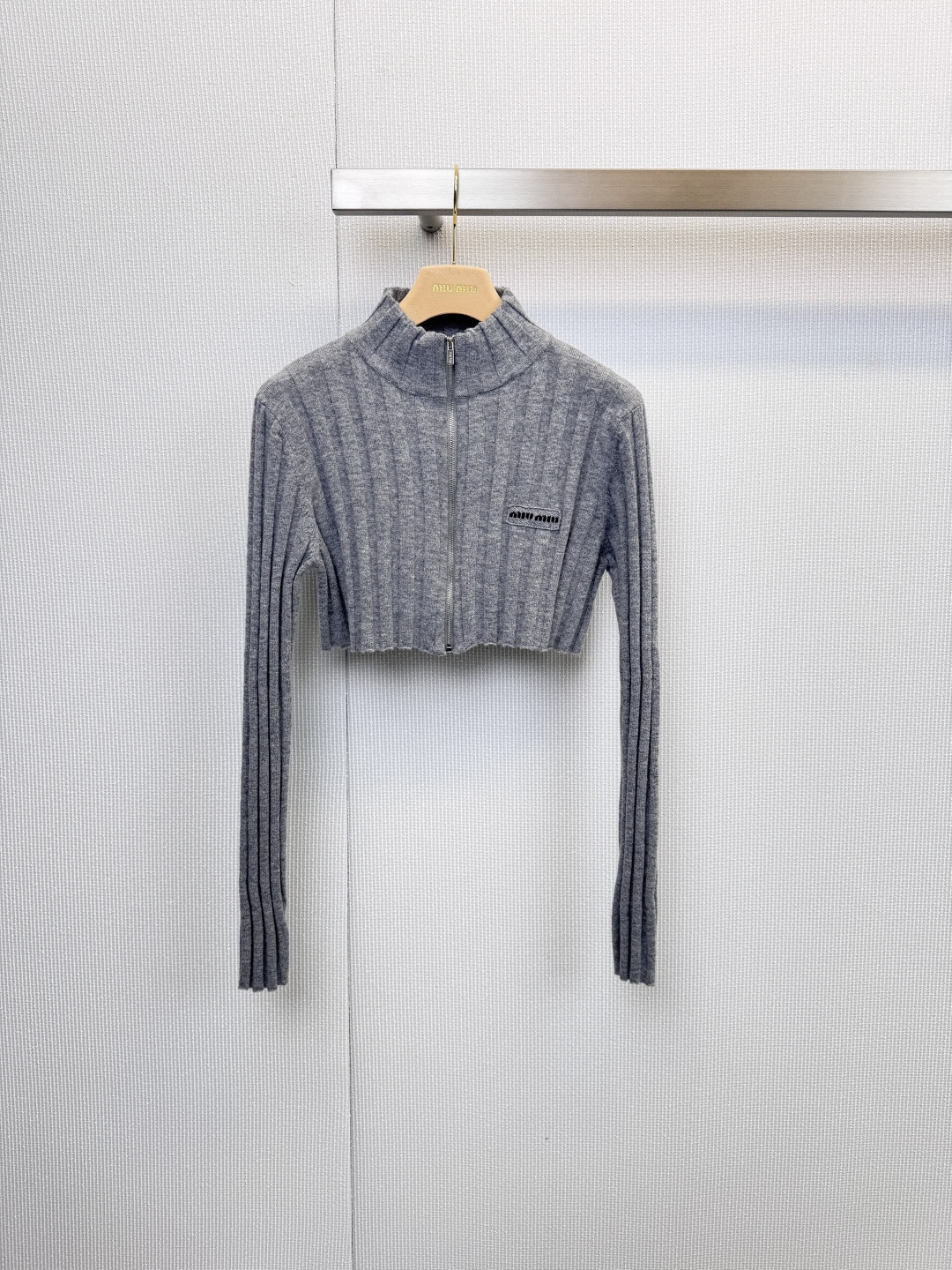 NO:623097,MiuMiu short zipper cardigan, Italian elegance, simple style, classic gray vertical stripe knitted fabric, giving the clothing a simple and modern texture, high collar design and silver zipper opening and closing, both warmth and neat lines, easily enhance the layering of the outfit, pure wool material, ensuring that the clothing has excellent skin-friendly feel, warmth and breathability, bringing a comfortable and luxurious wearing experience  , The black MiuMiu brand logo on the left chest shows the brand identity in a low-key manner, and the details are full of luxurious style. This short cardigan is an ideal choice for daily commuting, casual dating or holiday travel. It can be paired with high-waisted pants or skirts to easily create a smart and fashionable look. Size SML, miumiu, skirts, alexander  wang19860909MiuMiu短款拉链开衫,意式优雅,简约风尚,经典灰色竖条纹针织面料,赋予服装简约现代的质感,高领设计与银色拉链开合,兼具保暖性与利落线条,轻松提升穿搭层次感,纯羊毛材质,确保衣物拥有出色的亲肤感、保暖性和透气性,带来舒适奢华的穿着体验,左胸处的黑色MiuMiu品牌标志低调彰显品牌身份,细节之处尽显奢华格调,这款短款开衫是日常通勤、休闲约会或假日出行的理想选择,可搭配高腰裤或半身裙,轻松塑造出干练又时髦的造型.码数SML,,miumiu,skirts,alexander wang,Women's clothing