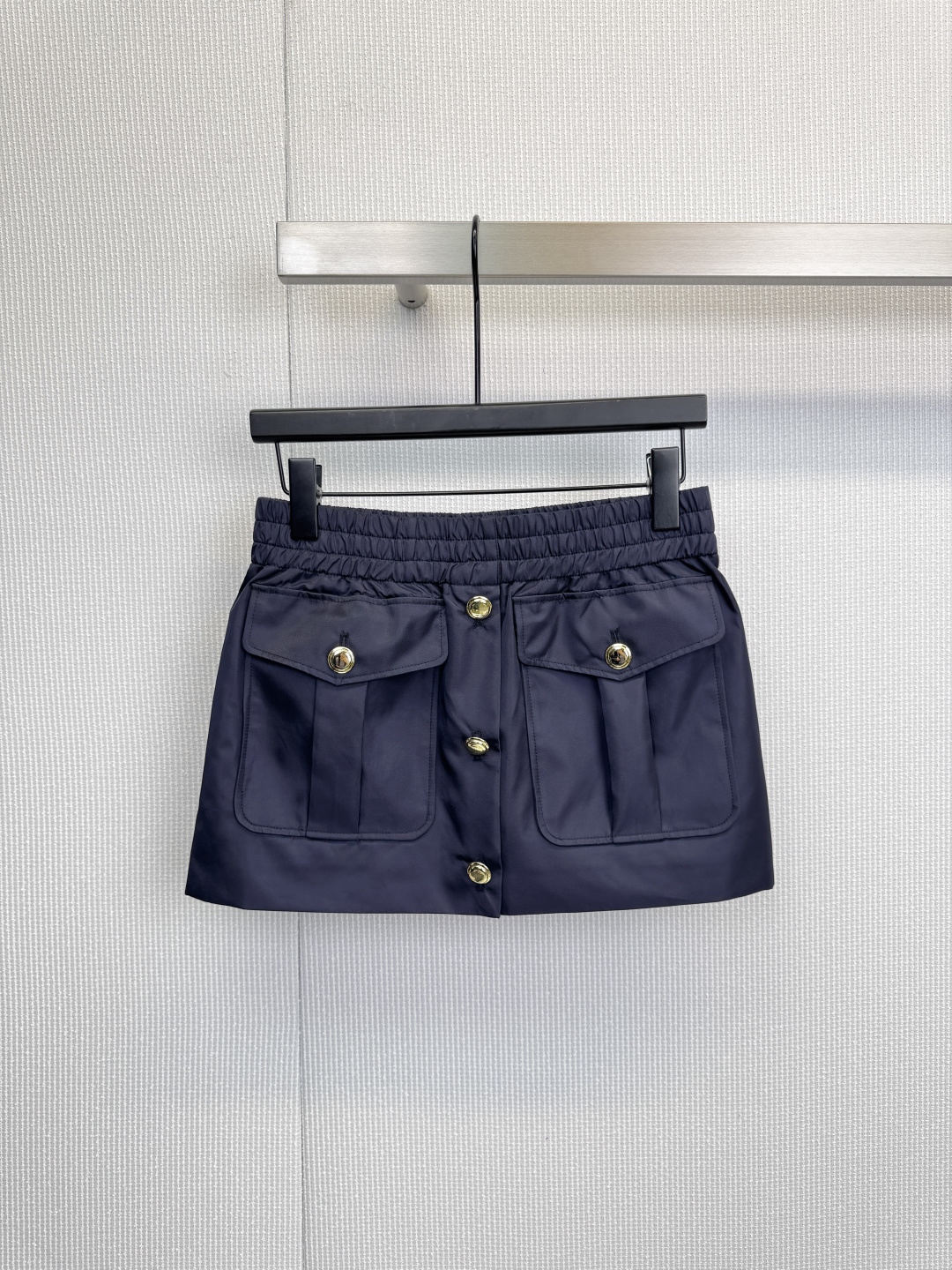 NO:623864,MiuMiu workwear-style skirt, a skirt in the same color as the jacket, continues the design language of workwear. The smooth nylon fabric has a subtle luster, which enhances the overall texture. The elastic high-waist design easily outlines the waistline and is easy to put on and take off. There are two large-capacity pockets in the front of the skirt and top-down  The three golden buttons arranged in a row perfectly echo the details of the jacket, balancing femininity and handsomeness. The slightly A-line skirt design not only modifies the figure, but also retains a sense of agility, making it suitable for various occasions.,,miumiu,skirts,jackets  & coats,alexander wang19860909MiuMiu工装风半裙,与夹克同色的半裙,延续了工装的设计语言.光滑的尼龙面料泛着微妙光泽,提升整体质感,松紧高腰设计轻松勾勒腰线,方便穿脱.裙身前方的两个大容量口袋及自上而下排列的三颗金色纽扣,与夹克细节完美呼应,平衡了柔美与帅气,略呈A字的裙摆设计,在修饰身材的同时,亦保留了灵动感,适合多种场合穿着.,,miumiu,skirts,jackets & coats,alexander wang,Women's clothing