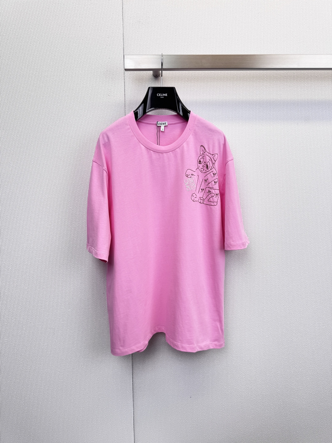 NO:625539,LOEWE's funny and cute cat T-shirt meets art and plays with fashion. When Spanish luxury craftsmanship meets playful artistic soul, this unique LOEWE was born.  T-shirts, the series includes soft pink and classic black. An exquisite print on the left chest shows a cute cartoon cat holding a bouquet. Its humorous and cute expression injects infinite vitality and imagination into the simple design. It perfectly interprets the modern aesthetics of being low-key and restrained yet playful. Adhering to the brand's consistent standards of excellence, the T-shirts are made of high quality  The high-quality cotton fabric ensures skin-friendly comfort and durability for daily wear. The classic cut is both casual and decent. The cute cat pattern on the left chest becomes the finishing touch of the overall look. It is low-key and highly recognizable. The unique cartoon cat and bouquet pattern at the core instantly breaks the dullness of the basic T-shirt, showing a unique  Extraordinary artistic taste, the pink is soft and sweet, and the black is cool and versatile, meeting the needs of different styles of dressing. It can be used as a personalized couple's outfit or a girlfriend's outfit. From the touch of the fabric to the clear brand label on the inside of the collar, every detail demonstrates LOEWE's craftsmanship. The pink model can be paired with light-colored denim or white bottoms to fully show off the style.  Fresh and romantic, the black model can be paired with overalls or leather skirts to create a cool street style. Worn alone or as an inner layer, it can easily become the visual focus of the overall look and tell your personality. Size SML, loewe, skirts, tees, t-shirt, alexander  wang19860909LOEWE 奇趣萌猫T恤,邂逅艺术,玩味时尚,当西班牙奢华工艺邂逅俏皮艺术灵魂,便诞生了这款与众不同的LOEWE T恤,系列包含柔美粉色与经典黑色两款,左胸处以精致印花呈现一只手持花束的卡通萌猫,其诙谐可爱的神态为简约设计注入无限活力与想象,完美诠释了低调内敛又不失玩趣的现代美学,秉承品牌一贯的卓越标准,T恤采用高品质棉质面料,确保穿着时的亲肤舒适感与日常穿着的耐久性,经典的版型剪裁,兼顾休闲与得体,左胸的萌猫图案成为整体造型的点睛之笔,低调而极具辨识度,核心独特的卡通猫与花束图案,瞬间打破基础款T恤的沉闷,展现独特不凡的艺术品味,粉色柔和甜美,黑色酷感百搭,满足不同风格的穿搭需求,可作为个性情侣装或闺蜜装,从面料触感到领口内侧清晰的品牌标签,每一处细节都彰显LOEWE的匠心工艺,粉色款可搭配浅色牛仔或白色下装,尽显清新浪漫,黑色款可搭配工装裤或皮质短裙,演绎酷感街头风,单穿或作为内搭,都能轻松成为整体造型的视觉焦点,诉说你的个性态度.码数SML,,loewe,skirts,tees，t-shirt,alexander wang,Women's clothing