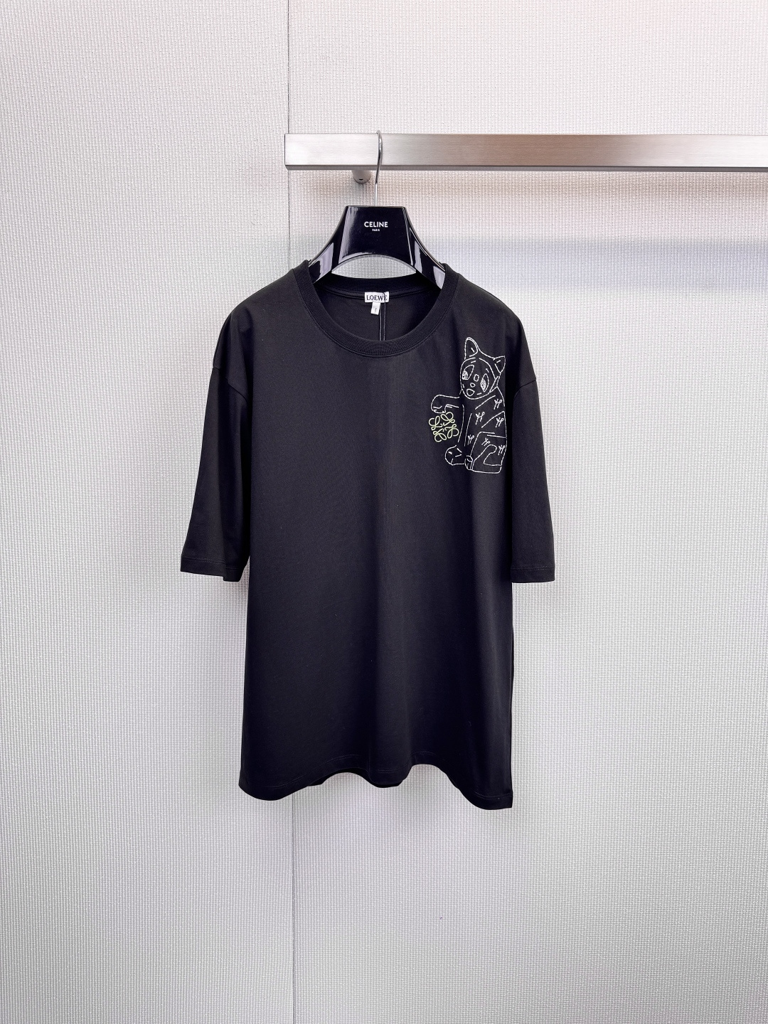 NO:625597,LOEWE's funny and cute cat T-shirt meets art and plays with fashion. When Spanish luxury craftsmanship meets playful artistic soul, this unique LOEWE was born.  T-shirts, the series includes soft pink and classic black. An exquisite print on the left chest shows a cute cartoon cat holding a bouquet. Its humorous and cute expression injects infinite vitality and imagination into the simple design. It perfectly interprets the modern aesthetics of being low-key and restrained yet playful. Adhering to the brand's consistent standards of excellence, the T-shirts are made of high quality  The high-quality cotton fabric ensures skin-friendly comfort and durability for daily wear. The classic cut is both casual and decent. The cute cat pattern on the left chest becomes the finishing touch of the overall look. It is low-key and highly recognizable. The unique cartoon cat and bouquet pattern at the core instantly breaks the dullness of the basic T-shirt, showing a unique  Extraordinary artistic taste, the pink is soft and sweet, and the black is cool and versatile, meeting the needs of different styles of dressing. It can be used as a personalized couple's outfit or a girlfriend's outfit. From the touch of the fabric to the clear brand label on the inside of the collar, every detail demonstrates LOEWE's craftsmanship. The pink model can be paired with light-colored denim or white bottoms to fully show off the style.  Fresh and romantic, the black model can be paired with overalls or leather skirts to create a cool street style. Worn alone or as an inner layer, it can easily become the visual focus of the overall look and tell your personality. Size SML, loewe, skirts, tees, t-shirt, alexander  wang19860909LOEWE 奇趣萌猫T恤,邂逅艺术,玩味时尚,当西班牙奢华工艺邂逅俏皮艺术灵魂,便诞生了这款与众不同的LOEWE T恤,系列包含柔美粉色与经典黑色两款,左胸处以精致印花呈现一只手持花束的卡通萌猫,其诙谐可爱的神态为简约设计注入无限活力与想象,完美诠释了低调内敛又不失玩趣的现代美学,秉承品牌一贯的卓越标准,T恤采用高品质棉质面料,确保穿着时的亲肤舒适感与日常穿着的耐久性,经典的版型剪裁,兼顾休闲与得体,左胸的萌猫图案成为整体造型的点睛之笔,低调而极具辨识度,核心独特的卡通猫与花束图案,瞬间打破基础款T恤的沉闷,展现独特不凡的艺术品味,粉色柔和甜美,黑色酷感百搭,满足不同风格的穿搭需求,可作为个性情侣装或闺蜜装,从面料触感到领口内侧清晰的品牌标签,每一处细节都彰显LOEWE的匠心工艺,粉色款可搭配浅色牛仔或白色下装,尽显清新浪漫,黑色款可搭配工装裤或皮质短裙,演绎酷感街头风,单穿或作为内搭,都能轻松成为整体造型的视觉焦点,诉说你的个性态度.码数SML,,loewe,skirts,tees，t-shirt,alexander wang,Women's clothing