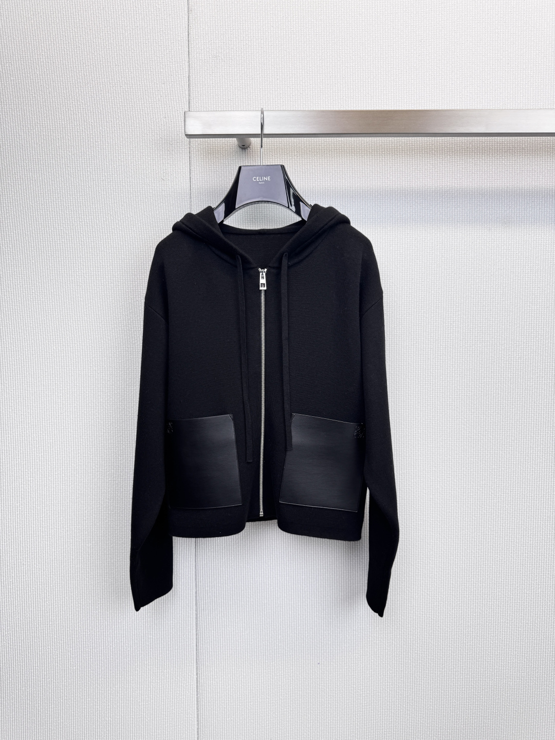 NO:628896,LOEWE  Hooded knitted zipper cardigan, urban roaming, and interpretation of relaxed aesthetics. This hooded knitted cardigan redefines modern casual style with refined tailoring and exquisite details. The classic hooded design and front zipper give the wearer a casual and comfortable experience. The hem is cleverly designed with asymmetrical design to create a comfortable look.  It breaks the rules and reveals a casual design sense in the dynamic. The high-quality leather patch pockets on both sides are not only practical, but also become the finishing touch, quietly improving the overall texture. The fabrics are strictly selected from 95% wool blended material, 4% nylon, 1% spandex, ensuring that the clothing has the natural warmth and soft touch of wool.  , while the blended material enhances elasticity and durability, making it comfortable and unrestricted to wear. Available in classic black and white and elegant off-white colors, it can be easily integrated into your daily wardrobe. Whether worn with a simple T-shirt and jeans to create a relaxed street look, or layered under a coat to inject a sense of relaxation into your commuting look.  It integrates LOEWE's insistence on craftsmanship into daily wear. It is a must-have item that combines comfort, texture and design. Size SML, loewe, jeans, tees, t-shirt, hats, alexander  wang19860909LOEWE 连帽针织拉链开衫,都市漫游,演绎松弛美学,这款连帽针织开衫,以精炼的剪裁与考究的细节,重新定义现代休闲风格,经典连帽设计与前襟拉链,赋予穿着者随性自在的体验.下摆巧妙采用不对称设计,打破常规,于动态间流露不经意的设计感,两侧的优质皮质贴袋,不仅实用,更成为点睛之笔,悄然提升整体质感,严格甄选面料用95羊毛混纺材质,4锦纶,1氨纶,确保衣物拥有羊毛的天然保暖性与柔软触感,同时混纺材质增强了弹力与耐用度,穿着舒适无拘束,提供经典黑白及雅致米白等配色,轻松融入日常衣橱.无论是内搭简约T恤与牛仔裤,营造轻松出街造型,还是层搭于大衣之内,为通勤装扮注入一份松弛感,皆能游刃有余,它将LOEWE对工艺的坚持融入日常穿着,是兼具舒适、质感与设计感的必备单品.码数SML,,loewe,jeans,tees，t-shirt,hats,alexander wang,Women's clothing