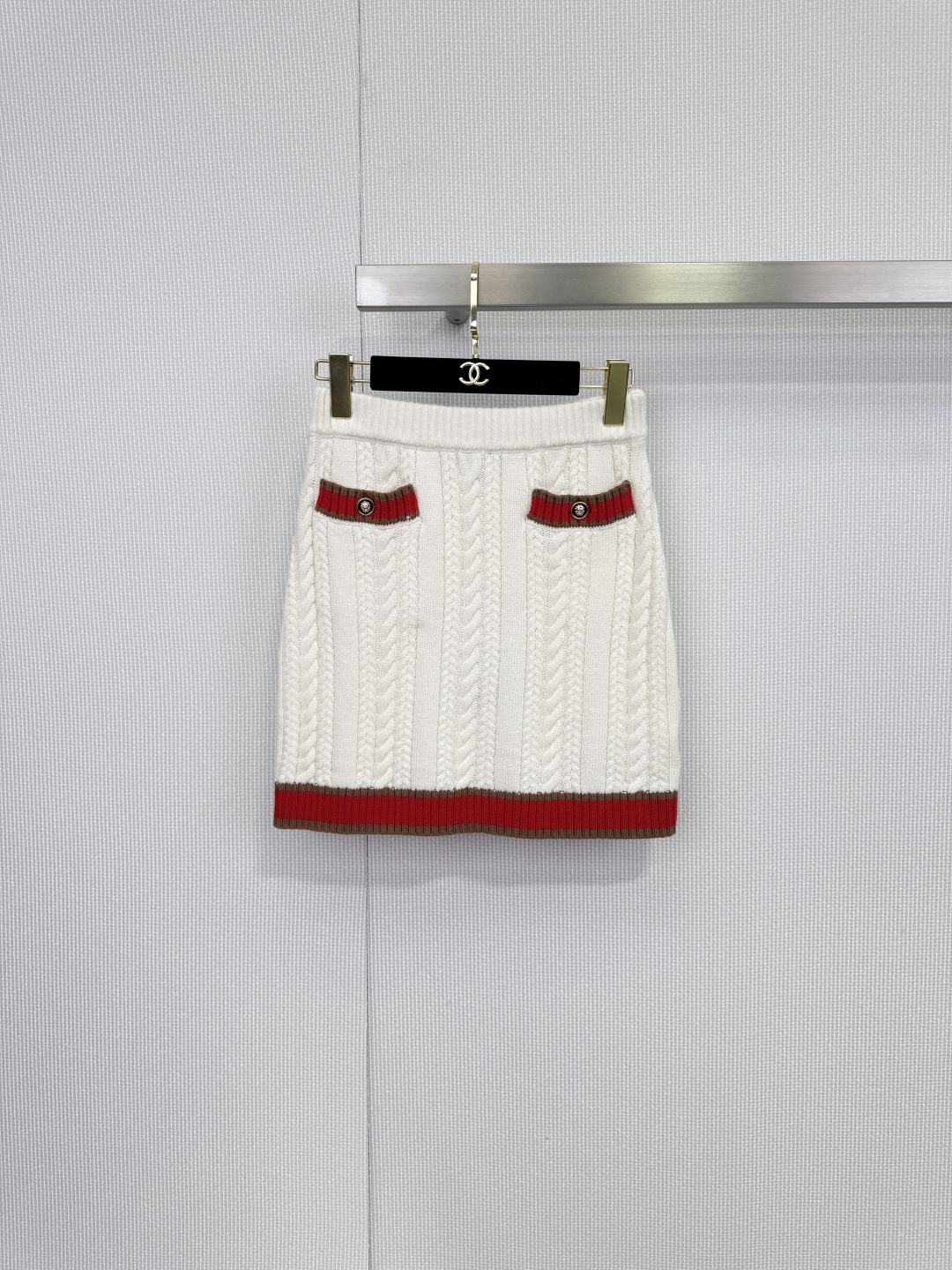 NO:648995,Chanel white twist knitted suit, an elegant interpretation of rare cashmere, you will fall in love at first sight, classic and timeless. This Chanel white knitted suit, with its simple and pure silhouette and exquisite craftsmanship, perfectly interprets the brand's timeless fashion charm. It feels as delicate and soft as clouds, giving the skin the ultimate luxurious wearing experience.  It is extremely light but has excellent warmth retention, highlighting the essence of low-key luxury. The overall use of thick-needle twist weaving texture is full of three-dimensionality, retro and elegant. The retro Polo lapel of the top, the exquisite five buttons, and the patch pocket design on both sides of the skirt all continue Chanel's iconic academic style and elegant style, and the iconic double C  The logo metal buckle is embellished on the side pockets of the skirt, quietly revealing the brand identity in the details. The red-brown webbing trim on the collar, cuffs and skirt not only creates a clever contrast with the white body, but also enriches the overall visual level and becomes the finishing touch. The top is a neat short version, and the bottom is a high-waisted A-line skirt, which can easily optimize the body proportions. The suit can be worn in combination to show a sense of integrity and luxury; it can also be separated into separate items to create a variety of styles. Size SML  skirt,,chanel,chanel,skirts,alexander wang19860909Chanel香奈儿白色麻花针织套装,珍稀羊绒的优雅诠释,一眼倾心,经典永恒,这款香奈儿白色针织套装,以简约纯粹的廓形与精湛工艺,完美演绎了品牌历久弥新的时尚魅力,触感细腻柔软如云,赋予肌肤极致奢宠的穿着体验,轻盈无比却拥有卓越的保暖性,彰显低调的奢华本质,整体运用粗针麻花编织纹理,立体感十足,复古又雅致.上衣的复古Polo翻领、精致的五颗纽扣,与短裙两侧的贴袋设计,均延续了香奈儿标志性的学院风与优雅格调,标志性双C logo金属扣点缀于裙侧口袋,于细节处悄然流露品牌身份.领口、袖口及裙摆处的红棕色织带镶边,不仅与白色主体形成巧妙撞色,更丰富了整体的视觉层次,成为画龙点睛之笔,上衣为利落短款版型,下装是高腰A字短裙,轻松优化身材比例,套装组合穿着,尽显整体感与高级感；亦可拆分为单品,搭配出多样风格. 码数SML 半裙,,chanel,chanel,skirts,alexander wang,Women's clothing