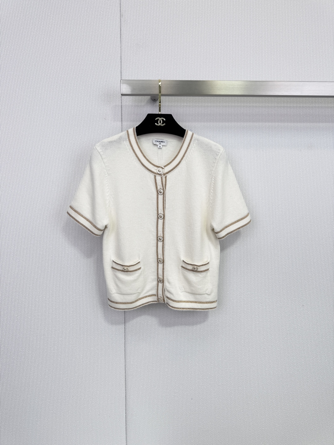 NO:648894,Chanel white short-sleeved knitted cardigan, a light poem woven with cashmere. Pure white meets warm cashmere. This Chanel short-sleeved knitted cardigan outlines timeless summer elegance with minimalist touches. The neckline, cuffs and hem are embellished with light brown ribbed trim, and are cleverly combined with decorative patch pockets on both sides.  Echoing the simple silhouette, the exquisite layers are outlined. A row of buttons of the same color on the front continues the brand's classic aesthetics and highlights the extraordinary taste in the details. The fabric is selected from 98 rare cashmere, giving you a luxurious touch of clouds. This product strictly follows the material standards of high fashion, with the luxurious 98 high-proportion cashmere as the core.  , weaving an extremely soft and skin-friendly texture. Incorporating 1 metallic fiber and 1 viscose fiber, it injects a soft luster and excellent drape into the fabric, ensuring that the silhouette is crisp yet flexible. Whether paired with skirts from the same series to create a complete and elegant look, or paired with high-waisted jeans for casual wear  Fashionable, this cardigan can become an indispensable and versatile item in your wardrobe, easily adapting to various occasions from daily commuting to afternoon dates. Size SML,,chanel,chanel,skirts,jeans,T-shirt,alexander  wang19860909Chanel香奈儿白色短袖针织开衫,以羊绒织就的轻盈诗篇,纯净白色邂逅温润羊绒,这件香奈儿短袖针织开衫以极简笔触勾勒出隽永的夏日优雅,领口、袖口与下摆点缀浅棕色罗纹镶边,与两侧装饰性贴袋巧妙呼应,在简约廓形中勾勒出精致层次.正面一排同色纽扣延续品牌经典美学,于细节处彰显不凡品味,甄选面料98珍稀羊绒,奢享云端触感,本品严格遵循高级时装的材质标准,以堪称奢华的98高比例羊绒为核心,织就无比软糯亲肤的质感.融入1金属感纤维与1粘胶纤维,为织物注入若隐若现的柔和光泽与优异垂坠感,确保廓形挺括而不失灵动,无论是搭配同系列半裙打造完整优雅造型,还是与高腰牛仔裤搭配演绎休闲时髦感,这件开衫都能成为您衣橱中不可或缺的百搭单品,轻松适应从日常通勤到午后约会的多种场合.码数SML,,chanel,chanel,skirts,jeans,T-shirt,alexander wang,Women's clothing