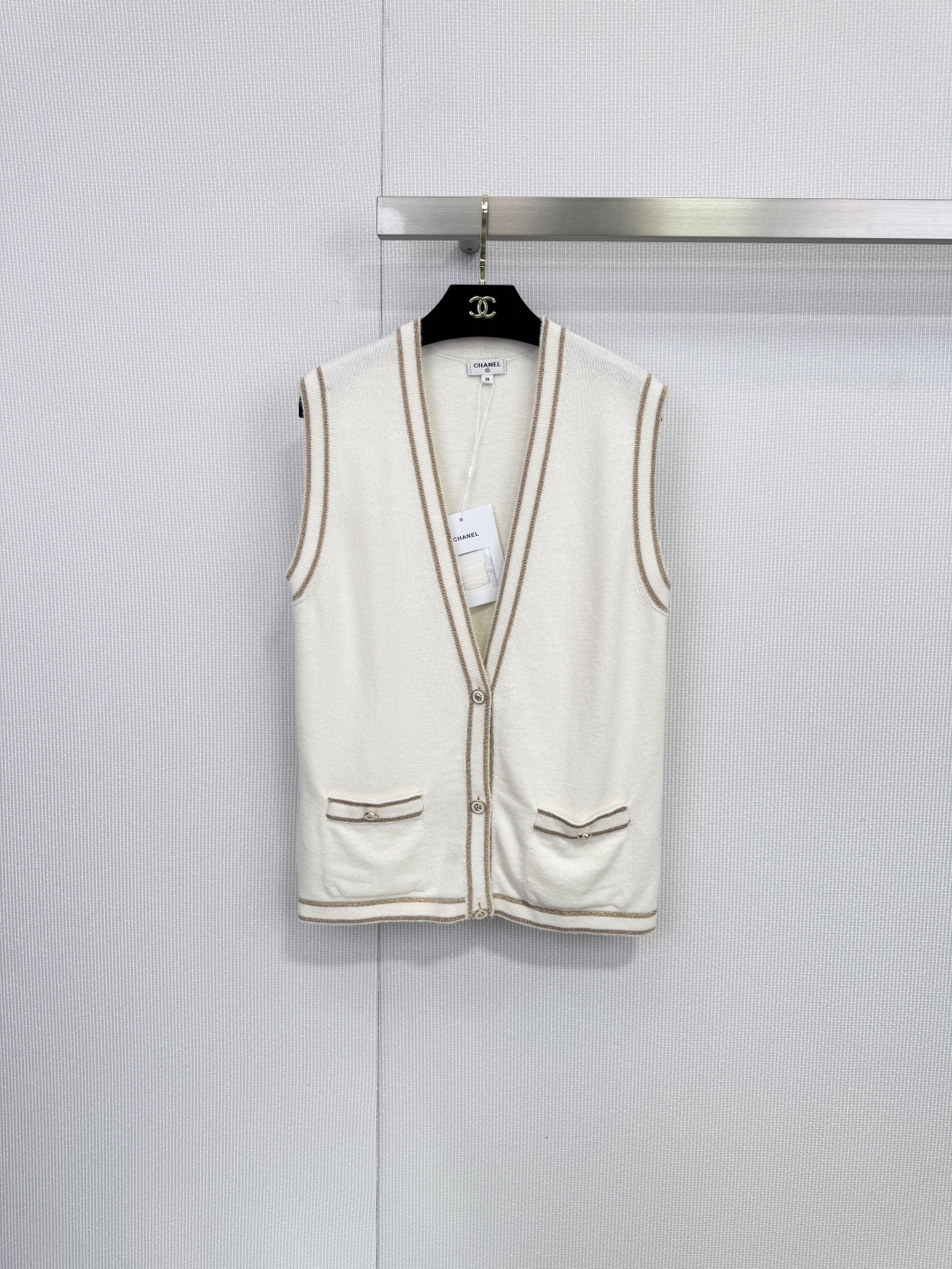 NO:648854,Chanel white V-neck knitted vest, a light poem woven with cashmere. Pure white meets warm cashmere. This Chanel short-sleeved knitted cardigan outlines timeless summer elegance with minimalist touches. The neckline, cuffs and hem are embellished with light brown ribbed trim, and are cleverly integrated with decorative patch pockets on both sides.  Echoing the simple silhouette, the exquisite layers are outlined. A row of buttons of the same color on the front continues the brand's classic aesthetics and highlights the extraordinary taste in the details. The fabric is selected from 98 rare cashmere, giving you a luxurious touch of clouds. This product strictly follows the material standards of high fashion, with the luxurious 98 high-proportion cashmere as the core.  , weaving an extremely soft and skin-friendly texture. Incorporating 1 metallic fiber and 1 viscose fiber, it injects a soft luster and excellent drape into the fabric, ensuring that the silhouette is crisp yet flexible. Whether paired with skirts from the same series to create a complete and elegant look, or paired with high-waisted jeans for casual wear  Fashionable, this cardigan can become an indispensable and versatile item in your wardrobe, easily adapting to various occasions from daily commuting to afternoon dates. Size SML,,chanel,chanel,skirts,jeans,T-shirt,alexander  wang19860909Chanel香奈儿白色V领针织马甲,以羊绒织就的轻盈诗篇,纯净白色邂逅温润羊绒,这件香奈儿短袖针织开衫以极简笔触勾勒出隽永的夏日优雅,领口、袖口与下摆点缀浅棕色罗纹镶边,与两侧装饰性贴袋巧妙呼应,在简约廓形中勾勒出精致层次.正面一排同色纽扣延续品牌经典美学,于细节处彰显不凡品味,甄选面料98珍稀羊绒,奢享云端触感,本品严格遵循高级时装的材质标准,以堪称奢华的98高比例羊绒为核心,织就无比软糯亲肤的质感.融入1金属感纤维与1粘胶纤维,为织物注入若隐若现的柔和光泽与优异垂坠感,确保廓形挺括而不失灵动,无论是搭配同系列半裙打造完整优雅造型,还是与高腰牛仔裤搭配演绎休闲时髦感,这件开衫都能成为您衣橱中不可或缺的百搭单品,轻松适应从日常通勤到午后约会的多种场合.码数SML,,chanel,chanel,skirts,jeans,T-shirt,alexander wang,Women's clothing