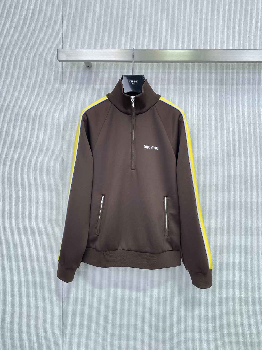 NO:657359,MiuMiu 2026 spring stand-up collar sports jacket, this dark brown stand-up collar sports jacket, the bright yellow stripes on the sleeves are super eye-catching, full of retro college style, high collar + half zipper design, warm and fashionable, the chest logo and two zipper pockets are full of details, loose version, tolerant of all body types, casually matched with sweaters or T-shirts are very layered, easy to wear in daily street, sweet and cool style, miumiu, hoodie, sweatshirts, jackets &  coats,tees,t-shirt,alexander wang19860909MiuMiu2026春款立领运动夹克,这款深棕色立领运动夹克,袖子亮黄条纹超吸睛,复古学院风满满,高领+半拉链设计,保暖又时髦,胸前logo和两个拉链口袋细节感十足,宽松版型,包容各种身材,随便搭配卫衣或T恤都很有层次感,日常出街轻松穿出甜酷风,,miumiu,hoodie,sweatshirts,jackets & coats,tees，t-shirt,alexander wang,Women's clothing