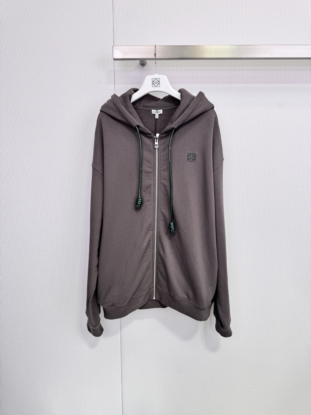 NO:659059,Loewe leather cord zipper hooded sweatshirt. This hooded sweatshirt has a low saturated gray tone and is very textured. It is made of soft cotton and is very comfortable to wear. It has an embroidered Anagram logo on the left chest and a black leather zipper. The white sailor knot on the hood is highly recognizable and is very delicate. It has a must-have attention to detail. It has a loose silhouette and is very fashionable to wear with jeans or wide-leg pants. It is easy to get a high-end casual style.  Size SML,,loewe,loewe,hoodie,sweatshirts,jeans,hats,alexander wang19860909Loewe罗意威皮绳拉链连帽卫衣,这款连帽卫衣低饱和灰调超有质感,柔软棉料穿着很舒服,左胸Anagram刺绣徽标+黑色皮质拉链,辨识度满分帽子上的白色水手结超精致,细节控必入,宽松廓形,随手搭牛仔裤 or阔腿裤都很时髦,轻松get高级休闲风. 码数SML,,loewe,loewe,hoodie,sweatshirts,jeans,hats,alexander wang,Women's clothing