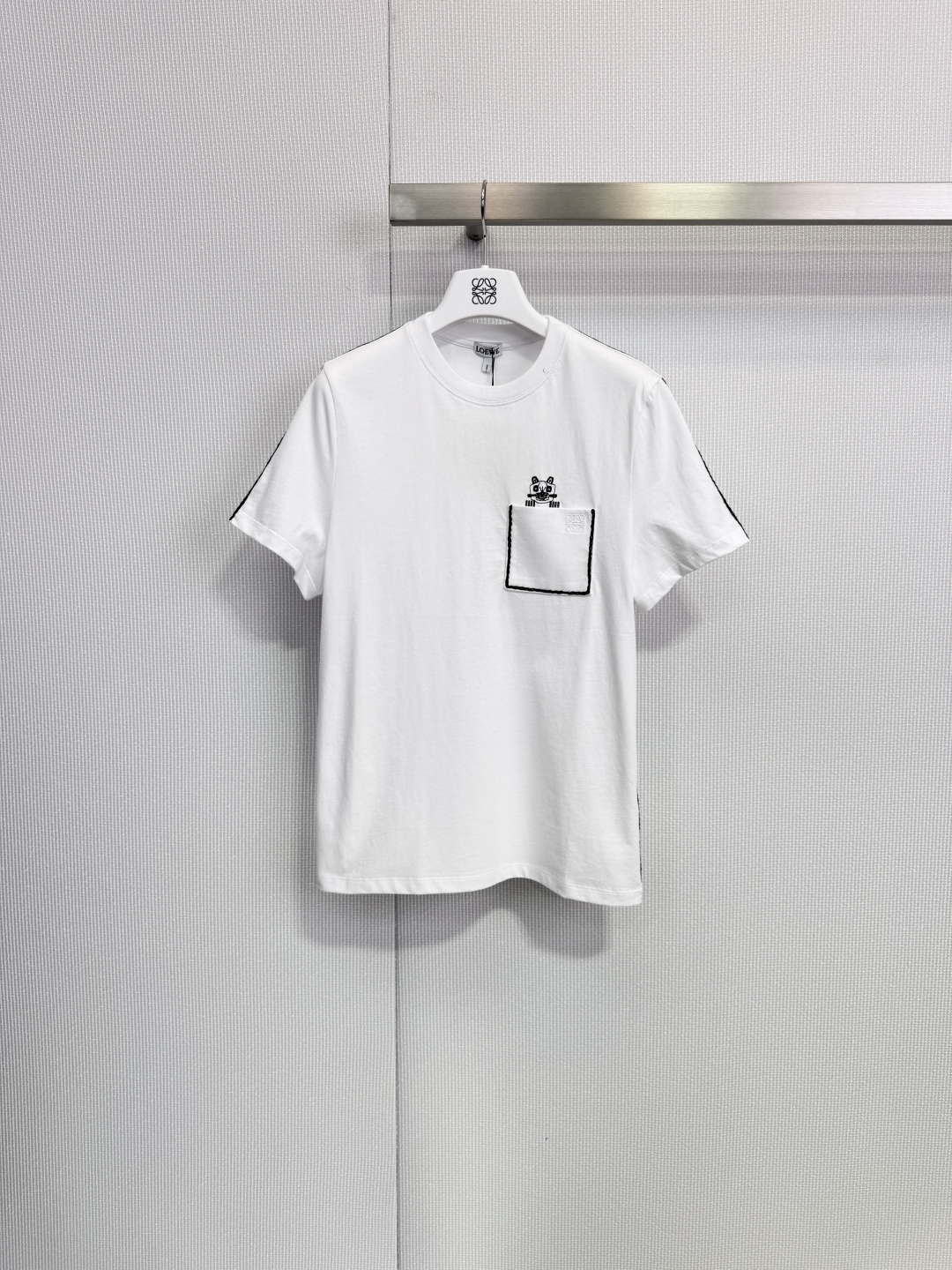 NO:666038,LOEWE x Louis Wain co-branded T-shirt LOEWE and British illustrator co-branded T-shirt, main color black + cat embroidery on the chest, full of fun and artistic sense! High-quality cotton material, soft and comfortable, no pressure for daily wear, loose fit, easy for both men and women to control, white hand-stitched details are super bonus, inspired by Louis Wain's classic cat illustrations, a must-have item for the 2026 early spring series, both trendy and collectible! Size SML, Louis Wain  vuitton,loewe,stuart weitzman,tees,t-shirt, 19860909LOEWE x Louis Wain联名T恤 LOEWE与英国插画家联名T恤,黑色主色+胸前猫咪刺绣,趣味十足又超有艺术感!高品质棉料,柔软舒适,日常穿搭无压力,宽松版型,男女都能轻松驾驭,白色手缝线细节超加分,灵感源自LouisWain经典猫咪插画,2026早春系列必入单品,潮流与收藏价值兼具! 码数SML,,louis vuitton,loewe,stuart weitzman,tees，t-shirt, ,Women's clothing