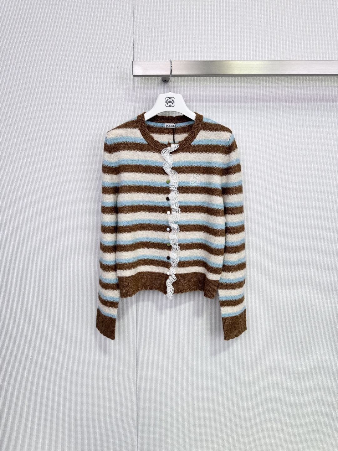 NO:686129,Loewe retro striped lace knitted cardigan, this knitted cardigan is designed with brown, light blue and off-white stripes, full of retro feel, and directly adds to the autumn and winter atmosphere! Lace placket + colorful buttons, super details, soft and skin-friendly fabrics, warm and comfortable, loose fit makes you slim and not flattering, small people can easily control it, can be worn for daily commuting, casual wear, it is gentle and casual with jeans or skirts, it is a versatile and practical item in autumn and winter!  Code numberSML,,loewe,skirts,jeans,19860909Loewe复古条纹蕾丝针织开衫,这款针织开衫采用咖色,浅蓝和米白条纹设计,复古感满满,秋冬氛围感直接拉满!门襟蕾丝花边+彩色纽扣,细节超加分,柔软亲肤面料,保暖又舒适,宽松版型显瘦不挑身材,小个子也能轻松驾驭,日常通勤,休闲都能穿,搭牛仔裤或半裙都很温柔随性,是秋冬百搭实用单品! 码数SML,,loewe,skirts,jeans,,Women's clothing