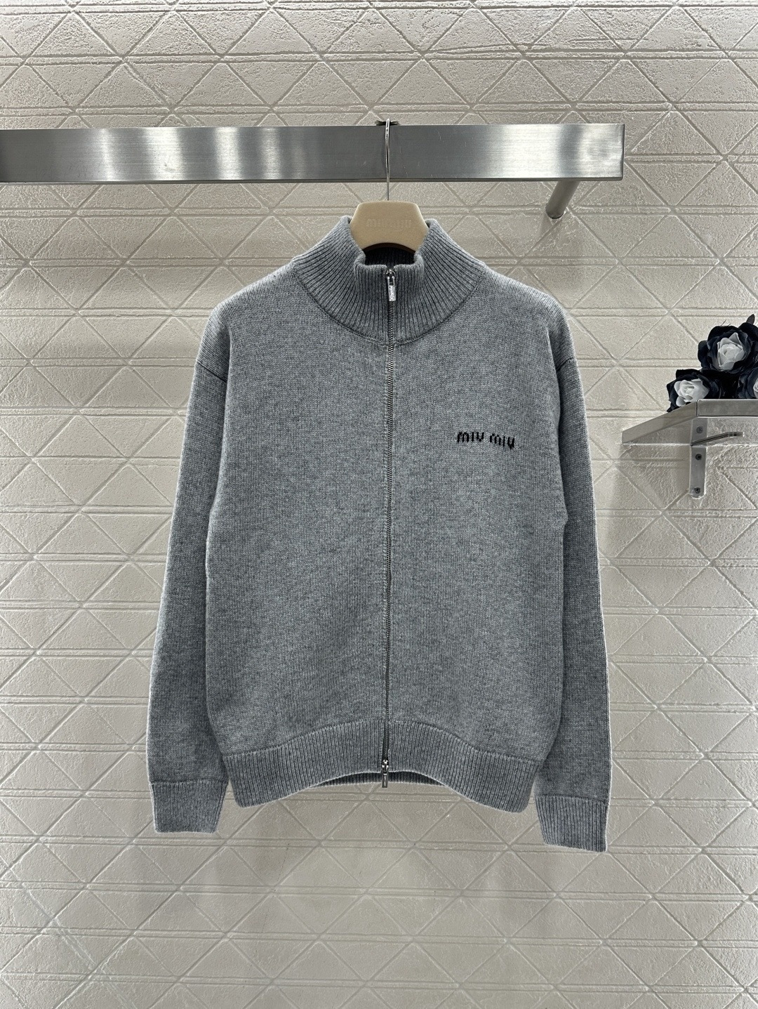 NO:686847,MiuMiu embroidered stand-up collar zipper cardigan, this gray stand-up collar zipper cardigan is made of high-quality knitted cotton, soft and warm, very suitable for autumn and winter, simple design with embroidered logo on the chest, low-key and recognizable, loose fit, stand-up collar zipper for easy putting on and taking off, ribbed cuffs and hem, comfortable and durable, it can be easily paired with jeans or casual pants for daily commuting and leisure, and you can easily get a lazy and high-end look!  Code number SML,,miumiu,jeans,19860909MiuMiu刺绣立领拉链开衫,这款灰色立领拉链开衫,采用高品质针织棉,柔软又保暖,秋冬穿超合适,简约设计加胸前刺绣Logo,低调又有辨识度,宽松版型,立领拉链方便穿脱,袖口和下摆罗纹收口,舒适又耐穿,日常通勤,休闲都能轻松搭配牛仔裤或休闲裤,轻松get慵懒高级感！ 码数SML,,miumiu,jeans,,Women's clothing