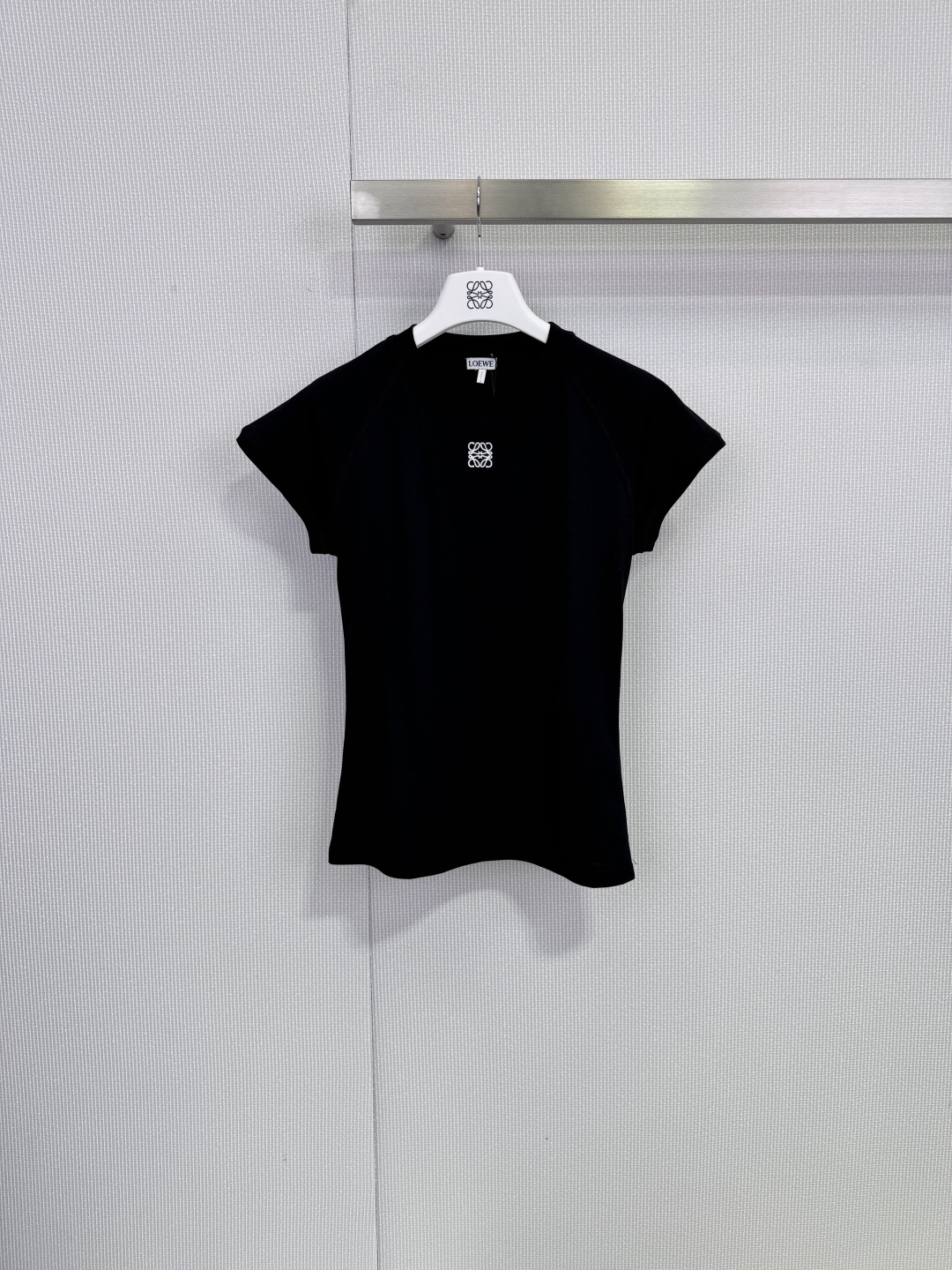 NO:694554,Loewe white slim T-shirt. This white slim T-shirt is made of high-quality pure cotton. It is soft and breathable. It is super comfortable to wear in spring and summer. It has a round neck with a straight shoulder and slim tailoring. It looks slim and neat. The brand embroidery on the chest is low-key and recognizable. It is versatile. It can be easily worn with jeans and skirts. It is suitable for daily outings or light casual occasions. It is available in black and white to meet the needs of different body types. It has a perfect sense of simplicity and luxury!  ,,loewe,skirts,jeans,tees,t-shirt,19860909Loewe白色修身T恤,这款白色修身T恤,采用高品质纯棉,柔软透气,春夏穿超舒服,正肩圆领+修身剪裁,显瘦又利落,胸前品牌刺绣低调有辨识度,百搭属性,牛仔裤、半裙都能轻松驾驭,日常出街或轻休闲场合都很适合,黑白两色可选,满足不同身材需求,简约高级感满分！,,loewe,skirts,jeans,tees，t-shirt,,Women's clothing