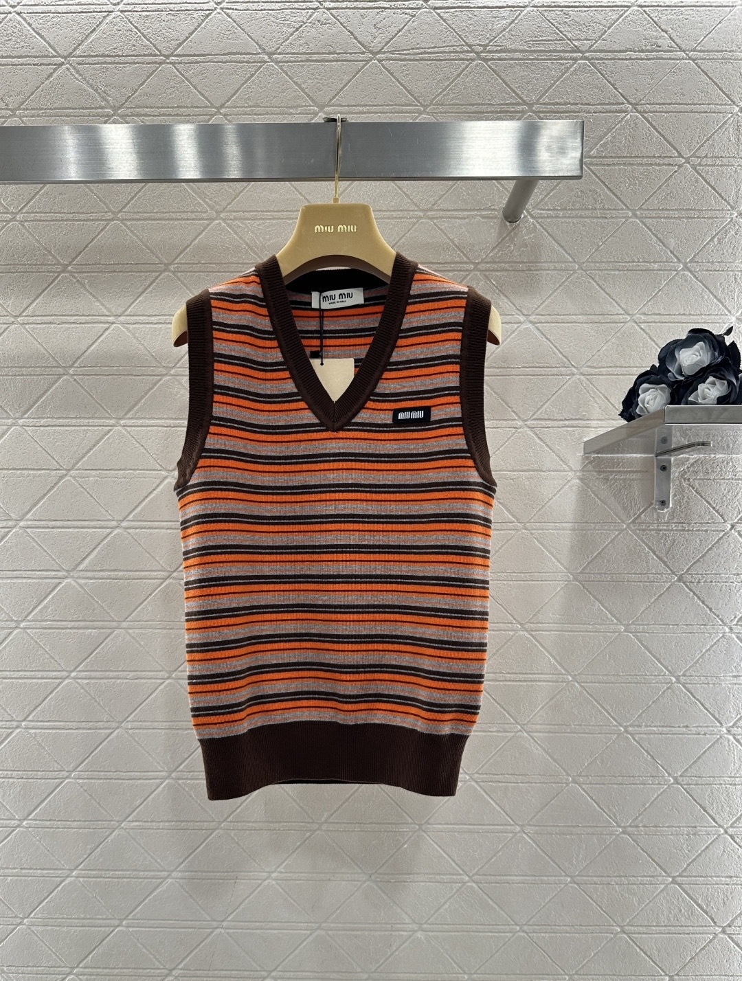 NO:697058,MiuMiu striped knitted vest, this striped knitted vest has an orange, gray and brown contrasting color design with a super retro feel. It has a V-neck sleeveless cut, which is great for layering or wearing alone in autumn and winter. The knitted fabric is soft and comfortable, and the loose fit is lazy and fashionable. The brand logo on the chest is perfect for recognition. Pair it with jeans or casual pants, and you can easily get Hong Kong style or retro style. It can be easily worn on the street or at parties every day!  Code number SML,,miumiu,jeans,19860909MiuMiu 条纹针织背心,这款条纹针织背心,橙灰棕撞色设计超有复古感,V领无袖剪裁,秋冬叠穿或单穿都很OK,针织面料柔软舒适,宽松版型慵懒又时髦,胸前品牌标识,辨识度满分,搭配牛仔裤或休闲裤,轻松get港风or复古风,日常出街、聚会都能轻松驾驭！ 码数SML,,miumiu,jeans,,Women's clothing
