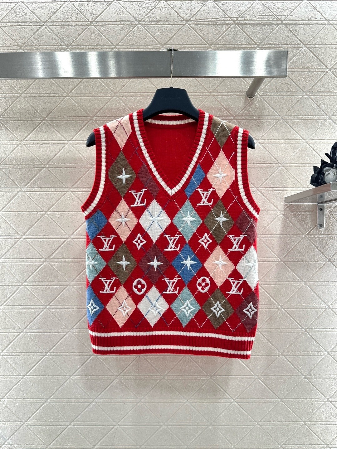 NO:707914,LV red rhombus knitted vest, this rhombus knitted vest has red main tone + multi-color rhombus, embellished with classic 'LV' and four-petal flowers, full of brand sense, the knitted fabric is soft and comfortable, V-neck sleeveless design, super versatile for autumn and winter layering, suitable for most body types, easy to control for daily commuting and leisure, match with shirt or turtleneck sweater, college style or retro style can be switched at will!  Size SML,,louis vuitton,sweaters,shirts,19860909LV红色菱格针织背心,这款菱格针织背心,红色主调+多色菱格,点缀经典“LV”和四瓣花,品牌感满满,针织面料柔软舒适,V领无袖设计,秋冬叠穿超百搭,适合大多数身材,日常通勤、休闲都能轻松驾驭,搭配衬衫或高领毛衣,学院风or复古风随心切换！ 码数SML,,louis vuitton,sweaters,shirts,,Women's clothing