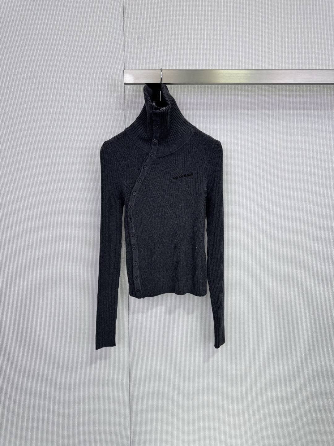 NO:708332,ANN ANDELMAN diagonal placket knitted top. This diagonal placket knitted top is made of black ribbed fabric. It has a slim fit and is very elegant for autumn and winter. It has a diagonal placket + button design, a perfect lapel shape, and the brand embroidery on the chest is very recognizable. The fabric is soft and comfortable. It can be worn alone or layered. It goes well with suit pants and skirts. It can be easily controlled in daily commuting. It has both design and practicality. It is a must-have fashionable item!  ,,skirts,business suit,19860909ANN ANDELMAN斜门襟针织上衣,这款斜门襟针织上衣,黑色罗纹面料,修身剪裁,秋冬穿超显气质,斜门襟+纽扣设计,翻领造型感满分,胸前品牌刺绣超有辨识度,面料柔软舒适,单穿或内搭都很OK,搭配西装裤、半裙都很出彩,通勤日常都能轻松驾驭,设计感与实用性兼具,时髦精必入！,,skirts,business suit,,Women's clothing