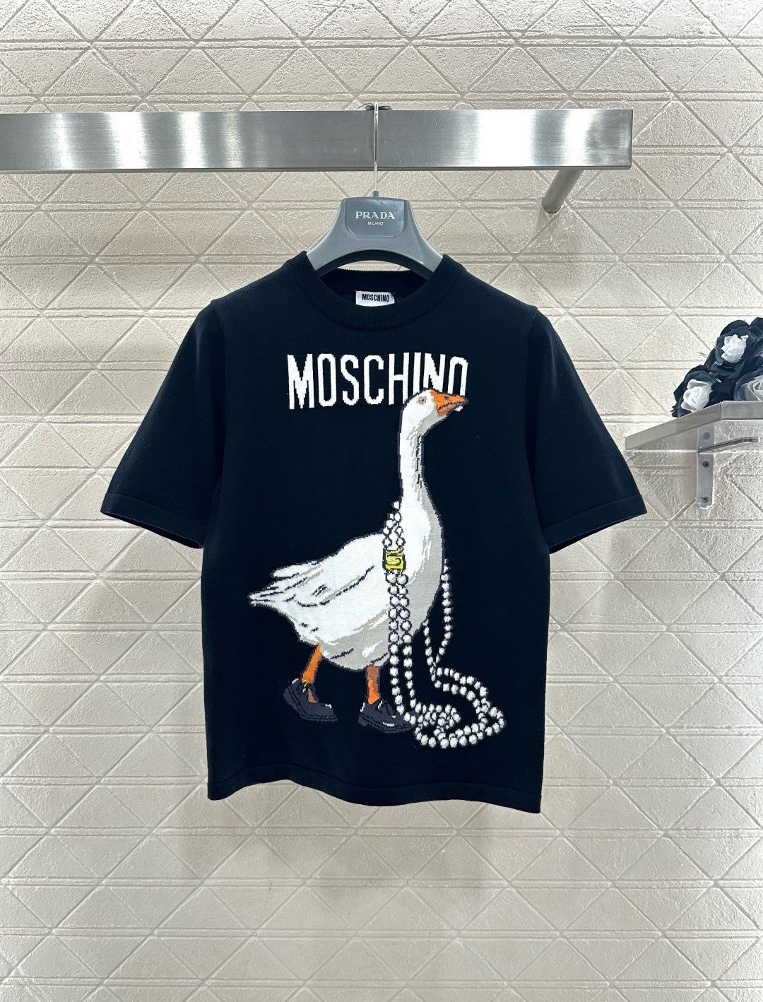 NO:709041,Moschino 25 early autumn series goose print knitted T-shirt, made of 100% cotton knitted fabric, soft and comfortable, super friendly for daily wear!  The black background is paired with a goose pattern. The goose wears a pearl necklace and Mary Jane shoes, which is fun and luxurious. The round neck design is simple and versatile, and it is great to wear alone or as an inner layer. It is easy to create a fashionable look. Moschino's iconic humorous style is a must-have for personalized wear!  Code number SML,,mary jane,tees,t-shirt,necklace,19860909Moschino 25早秋系列大鹅印花针织T恤,采用全棉针织面料,柔软舒适,日常穿着超友好！黑色底色搭配大鹅图案,鹅鹅佩戴珍珠项链和玛丽珍鞋,趣味又奢华.圆领设计简约百搭,单穿或内搭都很出彩,轻松打造时尚造型,Moschino标志性幽默风格,个性穿搭必备！码数SML,,mary jane,tees，t-shirt,necklace,,Women's clothing