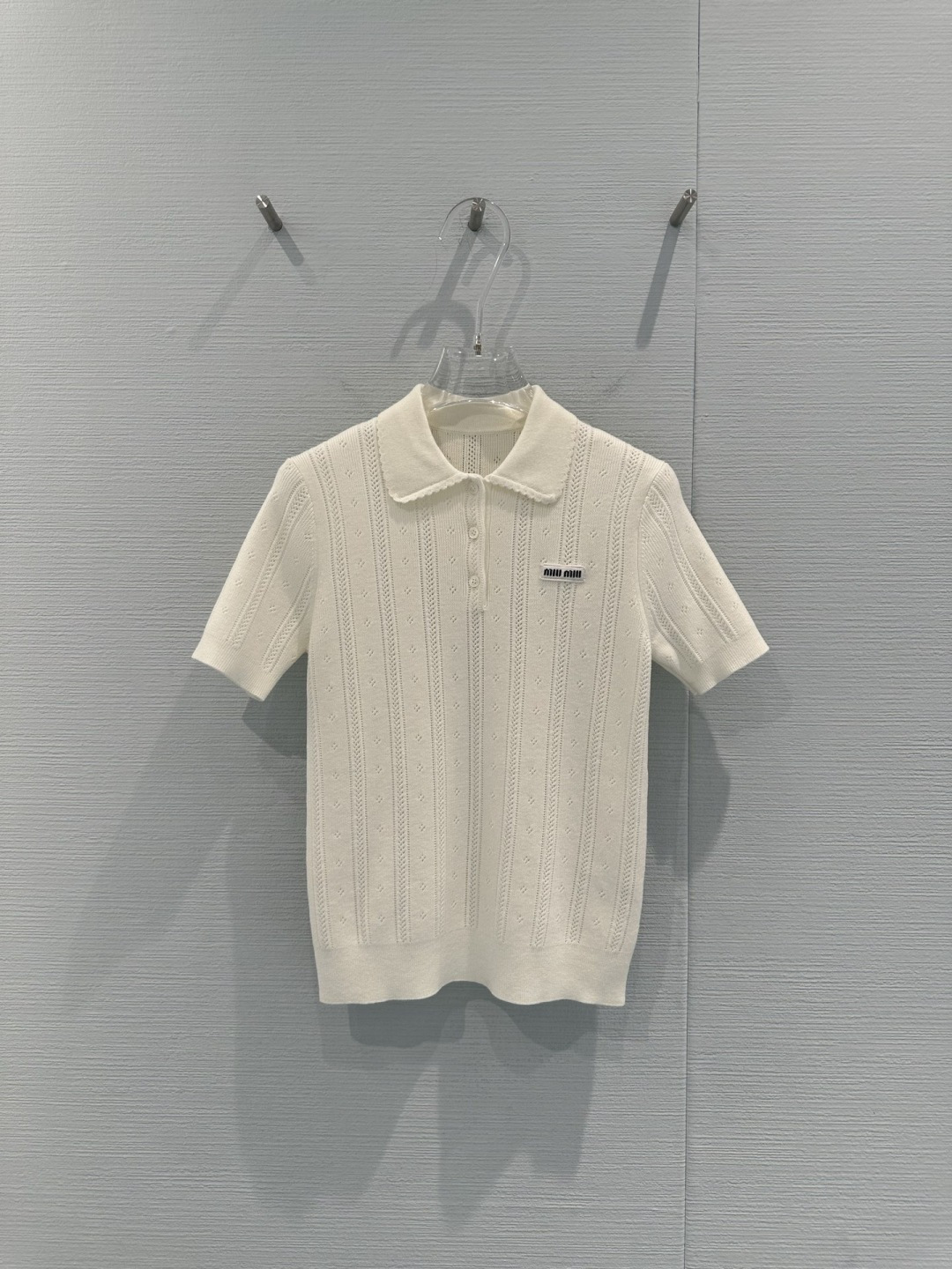 NO:709310,MiuMiu hollow knitted Polo shirt, this milky white hollow knitted Polo shirt, the vertical striped hollow design is super breathable, the fabric is light and breathable, super comfortable to wear in summer, the Polo lapel + black embroidered letters, full of college style, age-reducing and versatile, short-sleeved and loose version, looks good with high-waisted skirts or jeans, can be easily used for commuting, dating, and daily life, it is a must-have item for Miu style!  Size SML,,miumiu,skirts,jeans,T-shirt,19860909MiuMiu镂空针织Polo衫,这款奶白色镂空针织Polo衫,竖条纹镂空设计超有呼吸感,面料轻薄透气,夏天穿超舒服,Polo翻领+黑色刺绣字母,学院风满满,减龄又百搭,短袖宽松版型,搭高腰裙or牛仔裤都好看,通勤、约会、日常都能轻松驾驭,是Miu系穿搭必备单品！码数SML,,miumiu,skirts,jeans,T-shirt,,Women's clothing