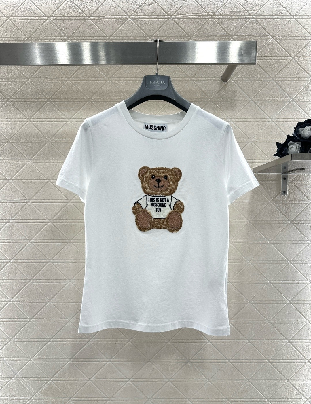 NO:709684,MOSCHINO bear embroidered short-sleeved T-shirt, this black pure cotton T-shirt, the bear embroidery on the front is very recognizable, with exquisite details and full of fun. The bear wears a white T-shirt with 'This is not a MOSCHINO toy' printed on it. It directly expresses the brand's attitude. It has a round neck design and a loose fit. It can be easily worn in daily casual or street style. It goes well with jeans and short skirts and is full of youthful vitality!  Size SML,,skirts,jeans,T-shirt,tees,t-shirt,19860909MOSCHINO小熊刺绣短袖T恤,这款黑色纯棉T恤,正面小熊刺绣超有辨识度,细节精致,趣味满满,小熊穿白T,印有“This is not a MOSCHINO toy”,品牌态度直接拉满,圆领设计,宽松版型,日常休闲或街头风都能轻松驾驭,搭配牛仔裤、短裙都很出彩,青春活力感十足！码数SML,,skirts,jeans,T-shirt,tees，t-shirt,,Women's clothing