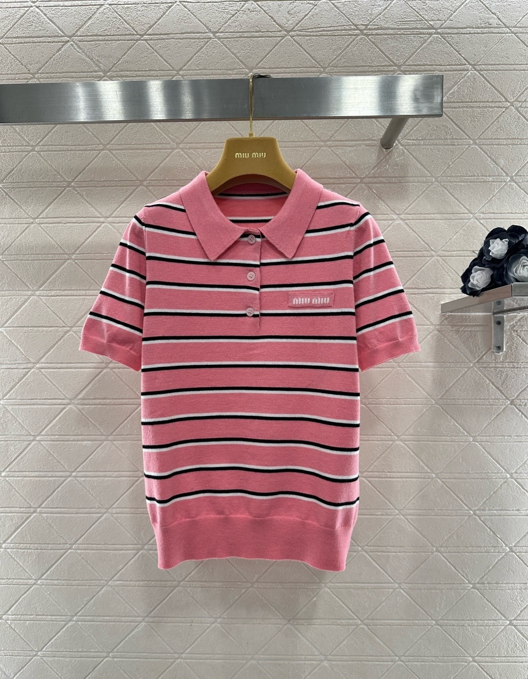 NO:709727,MiuMiu 2026 spring and summer series striped knitted Polo shirt, pink base with black and white stripes, full of college style, soft knitted fabric, comfortable and breathable, very suitable for spring and summer seasons, classic lapel + three buttons, brand embroidery on the chest, exquisite details, easy to control for daily commuting and leisure, paired with a pleated skirt or jeans, it will directly increase the sense of youthful vitality!  Code numberSML,,miumiu,skirts,jeans,19860909MiuMiu2026春夏系列条纹针织Polo衫,粉色底配黑白条纹,学院风满满,柔软针织面料,穿着舒适又透气,春夏季节超适合,经典翻领+三颗纽扣,胸前品牌刺绣,细节精致,日常通勤、休闲都能轻松驾驭,搭配百褶裙或牛仔裤,青春活力感直接拉满！码数SML,,miumiu,skirts,jeans,,Women's clothing