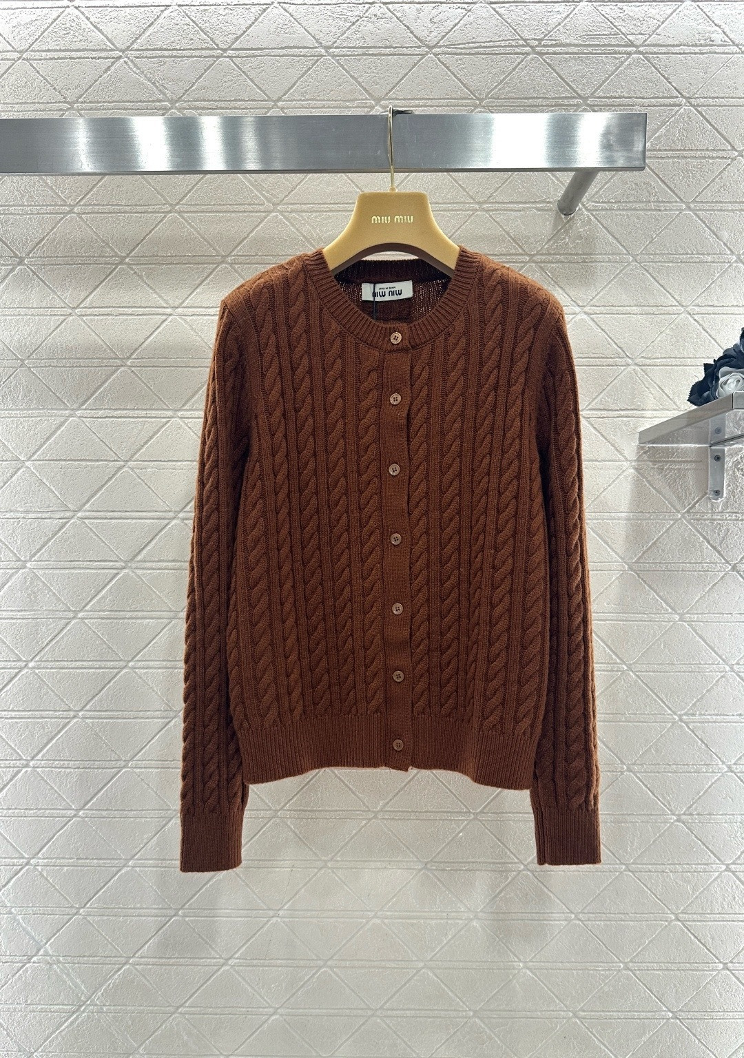 NO:713078,MiuMiu retro twist knitted cardigan, this retro twist knitted cardigan is made of wool, soft and warm, very suitable for autumn and winter, classic round neck + twist texture, full of retro feel, earthy brown has a super autumn and winter atmosphere, metal buttons are embellished, and the details are exquisite. The short design looks great with high-waisted pants or skirts, and can be easily worn for commuting and leisure. It is a must-have and versatile item for autumn and winter wardrobes!  Code numberSML,,miumiu,skirts,19860909MiuMiu复古麻花针织开衫,这款复古麻花针织开衫,采用羊毛,柔软又保暖,秋冬穿超合适,经典圆领+麻花纹理,复古感满满,土棕色超有秋冬氛围感,金属纽扣点缀,细节精致,短款设计搭高腰裤或裙都很出彩,通勤休闲都能轻松驾驭,是秋冬衣橱必备百搭单品！ 码数SML,,miumiu,skirts,,Women's clothing