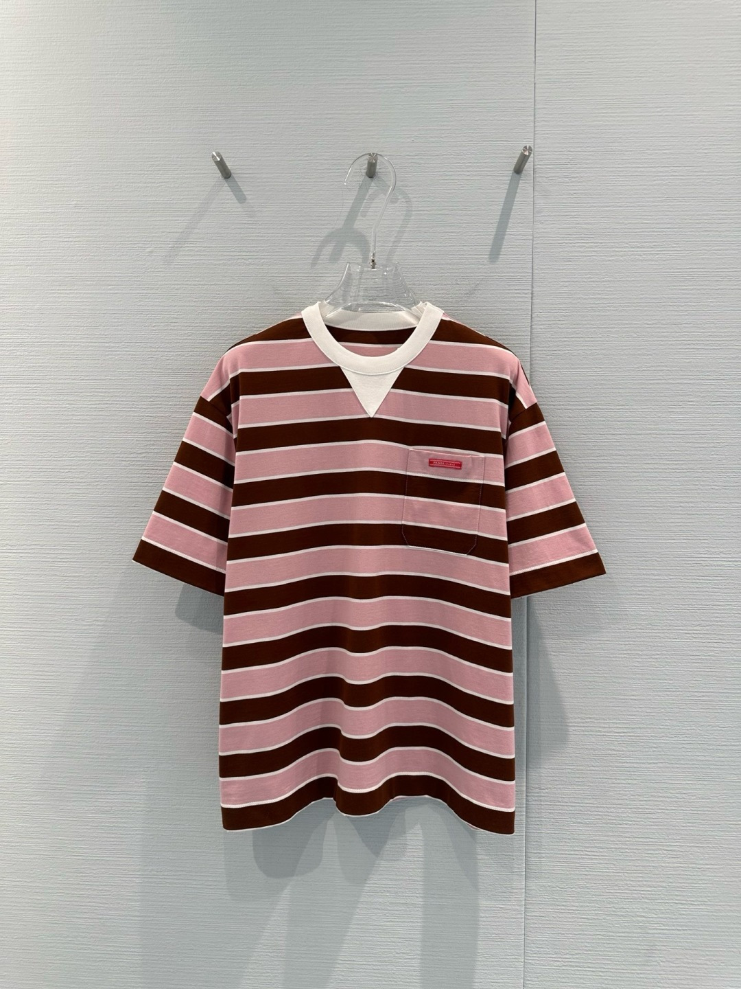 NO:713528,Prada 2026 early spring series pink and brown striped T-shirt, soft cotton fabric, super comfortable to wear, wide pink and brown stripes + white V-neck, small red logo pocket on the chest, full of details, loose fit, tolerant of a variety of body types, can be worn alone or layered, easy to create casual or retro style, striped design is classic and versatile, can be easily used for daily outings and parties, fashionable and practical!  Size SML,,prada,tees,t-shirt,19860909Prada 2026早春系列粉棕条纹T恤,柔软棉质面料,穿着超舒适,粉棕宽条纹+白色V领,胸前红色Logo小口袋,细节满分,宽松版型,包容多种身材,单穿或内搭都很OK,轻松打造休闲或复古风,条纹设计经典百搭,日常出街、聚会都能轻松驾驭,时髦又实用！码数SML,,prada,tees，t-shirt,,Women's clothing