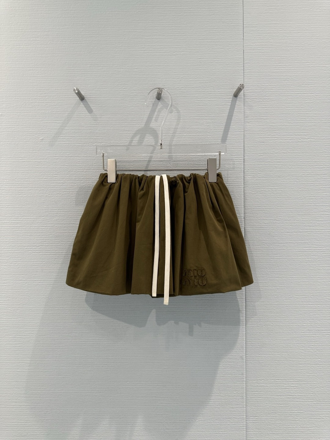 NO:716071,MiuMiu 2026 Spring Military Green Puff Skirt. This military green puff skirt features an elastic waist design with natural pleats. The A-line shape is super slim, light and comfortable. It is great for daily wear or outdoor activities. The military green color is full of retro feel. Pair it with a light-colored top or boots to easily get the American retro style. The anti-exposure design is super considerate. It is also very practical in autumn and winter. It is both beautiful and functional. It is the first choice for versatile short skirts!  Code numberSML,,miumiu,boots,skirts,19860909MiuMiu2026春款军绿色蓬蓬短裙,这款军绿色蓬蓬短裙采用松紧腰设计,褶皱自然,A字版型超显瘦,轻盈又舒适,日常穿搭或户外活动都很OK,军绿色复古感满满,搭配浅色上衣或靴子,轻松get美式复古风,防走光设计超贴心,秋冬季节也很实用,兼具美观与功能性,是百搭短裙首选！码数SML,,miumiu,boots,skirts,,Women's clothing