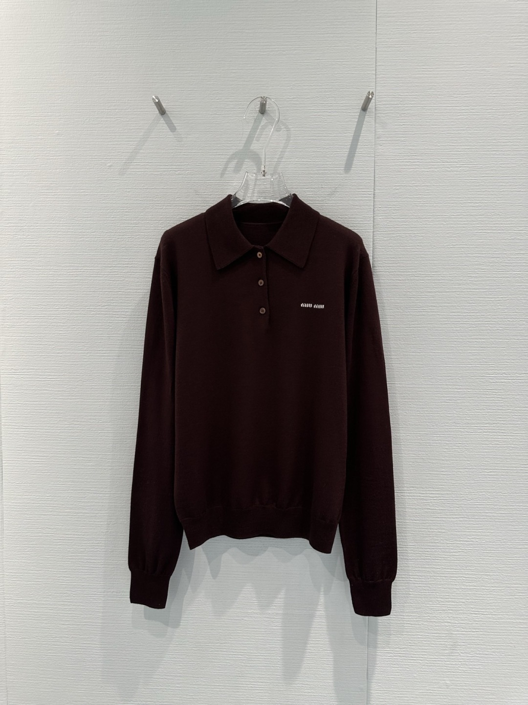 NO:716509,MiuMiu dark brown long-sleeved Polo shirt, made of wool, is soft and breathable, super comfortable to wear in autumn and winter!  Classic lapel + three buttons, logo embroidery on the chest is very recognizable, loose fit, fake two-piece design is full of layers, it is OK to wear alone or layered, dark brown is retro and versatile, it can be easily worn in college style or commuting style, it looks great with high-waist skirt or jeans!  Code numberSML,,miumiu,skirts,jeans,19860909MiuMiu深棕长袖Polo衫,羊毛材质柔软透气,秋冬穿超舒服！经典翻领+三颗纽扣,胸前徽标刺绣超有辨识度,宽松版型,假两件设计层次感满满,单穿或叠穿都很OK,深棕色复古百搭,学院风or通勤风都能轻松驾驭,配高腰裙or牛仔裤都很出彩！码数SML,,miumiu,skirts,jeans,,Women's clothing