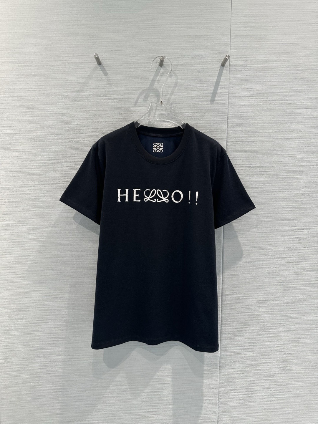 NO:729951,LOEWE 2026 early spring series Hello printed T-shirt, made of high-count combed cotton, soft and skin-friendly, breathable, super comfortable to wear, 'Hello' letter + double 'L' logo on the chest, burnt flower craftsmanship is super textured, slim fit, looks great when worn alone or layered with shirts, easy to create a casual and high-end sense, black and versatile, can be matched with jeans and skirts, it will turn heads every day when out on the street!  Size SML,,loewe,skirts,jeans,shirts,tees,t-shirt,19860909LOEWE 2026早春系列Hello印花T恤,采用高支精梳棉,柔软亲肤又透气,穿着超舒适,胸前“Hello”字母+双“L”Logo,烧花工艺超有质感,修身剪裁,单穿或叠搭衬衫都很出彩,轻松打造休闲高级感,黑色百搭,牛仔裤、短裙随心配,日常出街回头率up！码数SML,,loewe,skirts,jeans,shirts,tees，t-shirt,,Women's clothing