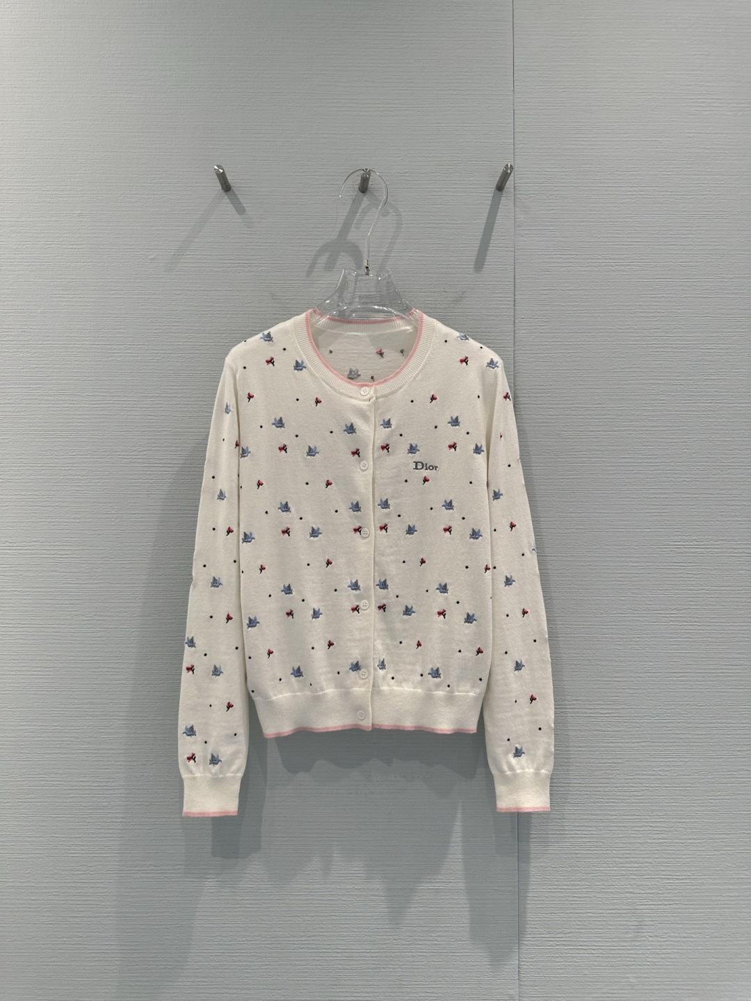 NO:731710,Dior 2026 early spring series peace dove knitted cardigan, made of white cashmere, soft and comfortable, embellished with red and blue peace dove embroidery, full of girlish feeling, round neck + pink piping, exquisite details, front button design, easy to put on and take off, can be easily used for daily commuting and leisure, it goes well with skirts or jeans, elegant and playful, it is a must-have item for early spring wardrobe!  Code numberSML,,dior,skirts,jeans,19860909Dior 2026早春系列和平鸽针织开衫,白色羊绒材质,柔软舒适,点缀红蓝和平鸽刺绣,少女感满满,圆领+粉色滚边,细节精致,正面纽扣设计,穿脱方便,日常通勤、休闲都能轻松驾驭,搭配裙装或牛仔裤都很出彩,优雅又俏皮,是早春衣橱必备单品！ 码数SML,,dior,skirts,jeans,,Women's clothing