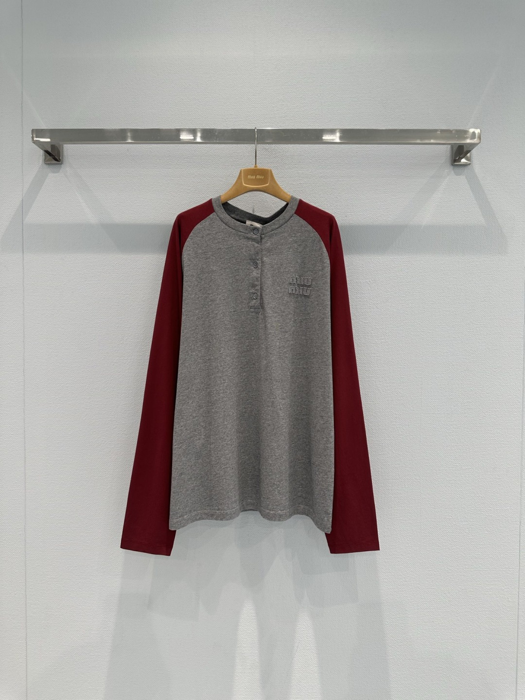 NO:734787,MiuMiu 2026 spring and summer series color-blocked raglan sleeve T-shirt, gray + Angora red splicing, retro and fashionable, soft and comfortable cotton fabric, super detailed collar button design, brand embroidery on the chest, perfect recognition, raglan sleeves cut with freedom of movement, can be easily controlled in daily casual or street style, match with bottoms or sneakers of the same color, and easily get a youthful and energetic look!  Size SML,,miumiu,sneakers,tees,t-shirt,19860909MiuMiu2026春夏系列拼色插肩袖T恤,灰色+安哥拉红拼接,复古又时髦,棉质面料柔软舒适,领口纽扣设计超有细节感,胸前品牌刺绣,辨识度满分,插肩袖剪裁活动自如,日常休闲或街头风都能轻松驾驭,搭配同色系下装或运动鞋,轻松get青春活力造型！ 码数SML,,miumiu,sneakers,tees，t-shirt,,Women's clothing