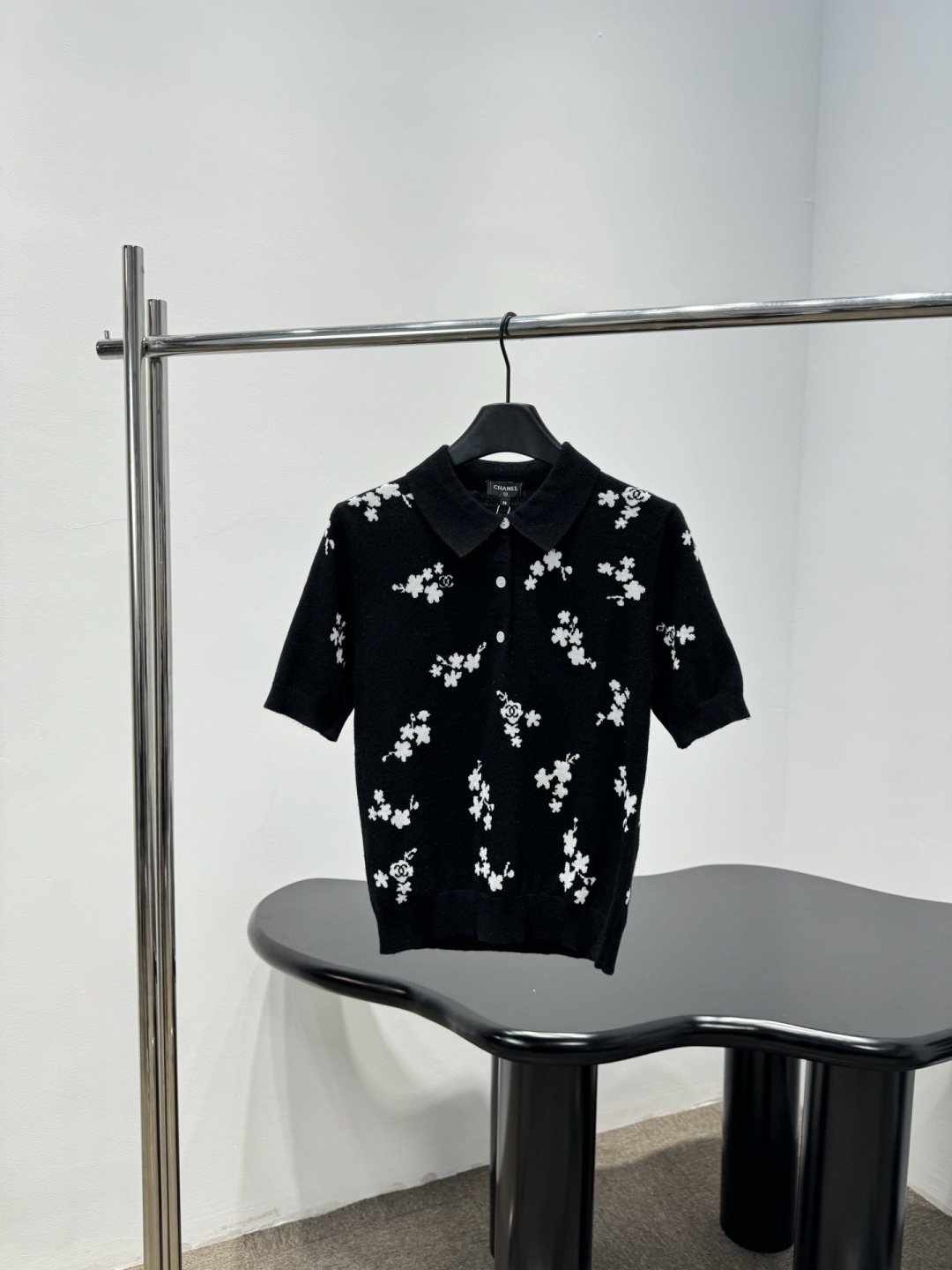NO:735671,Chanel black floral knitted short-sleeved POLO shirt, this black floral knitted short-sleeved POLO shirt is made of soft knitted fabric, comfortable and breathable, with white floral embellishment, simple and detailed, classic POLO collar + short-sleeved design, very suitable for spring and summer, easy to control for daily commuting and leisure, it goes well with jeans or casual pants, there is a brand logo on the inside of the collar, full of details, low-key and textured, suitable for sisters who like simple style!  Size SML,,chanel,jeans,T-shirt,19860909Chanel黑色碎花针织短袖POLO衫,这款黑色碎花针织短袖POLO衫,柔软针织面料,穿着舒适透气,白色碎花点缀,简约又有细节感,经典POLO领+短袖设计,春夏季节超适合,日常通勤、休闲都能轻松驾驭,搭配牛仔裤或休闲裤都很OK,衣领内侧有品牌标识,细节满分,低调又有质感,适合喜欢简约风的姐妹们！ 码数SML,,chanel,jeans,T-shirt,,Women's clothing