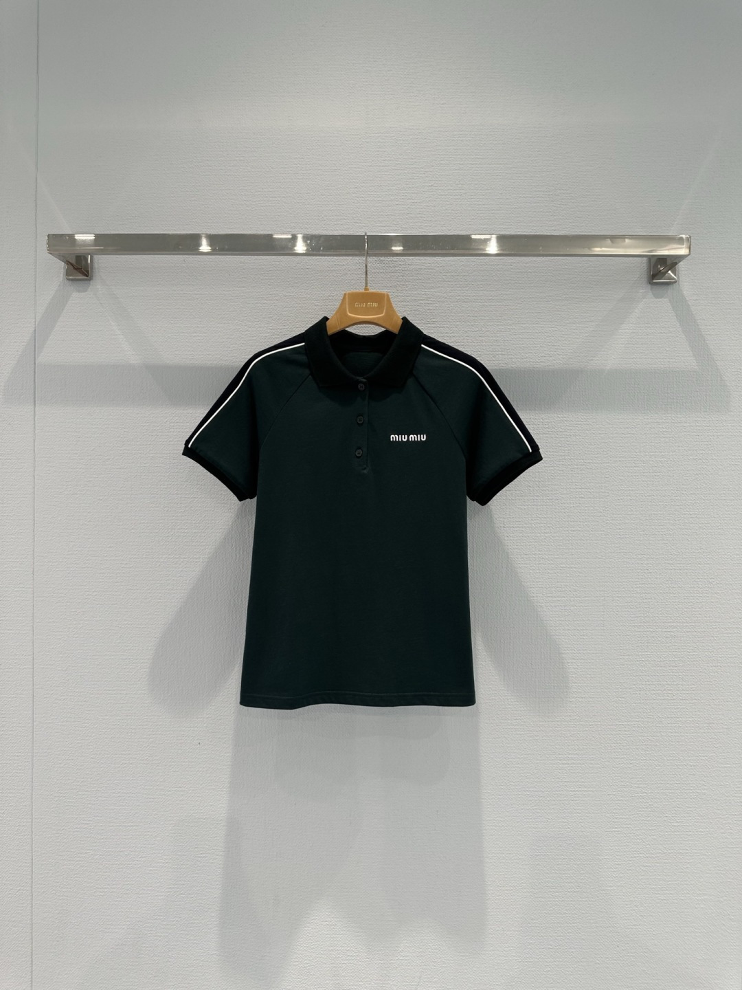 NO:737314,MiuMiu Dark Green Polo Shirt This dark green Polo shirt has a classic lapel + white stripes. It is full of college style. The fabric is skin-friendly and breathable. It is super comfortable to wear in summer. It has brand embroidery on the chest and exquisite details. The cuffs and collar are designed with contrasting colors. It has a layered look. It can be easily used for daily commuting and leisure. Paired with shorts or skirts, it has a sweet and cool style. The dark green color is white and does not pick on the skin tone. It is a must-have for early summer!  Code numberSML,,miumiu,skirts,shorts,19860909MiuMiu墨绿色Polo衫这款墨绿色Polo衫,经典翻领+白色条纹,学院风满满,面料亲肤透气,夏天穿超舒服,胸前品牌刺绣,细节精致,袖口和领口撞色设计,层次感up,日常通勤、休闲都能轻松驾驭,搭配短裤或半裙,甜酷风get,墨绿色显白不挑肤色,初夏穿搭必备！码数SML,,miumiu,skirts,shorts,,Women's clothing